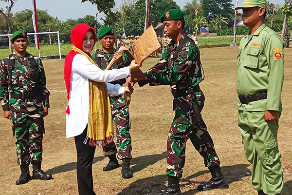 Bupati Sri Mulyani menyerahkan secara simbolis alat kerja kepada anggota TNI dan Linmas pada pembukaan KBM Klaten Bersinar 2019.