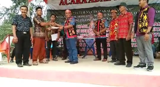 Presdir PT MAS Nanang Ibnur Rosyid sedang menyerahkan beasiswa kepada tiga mahasiswa berprestasi di desa sekitar kawasan PT MAS.