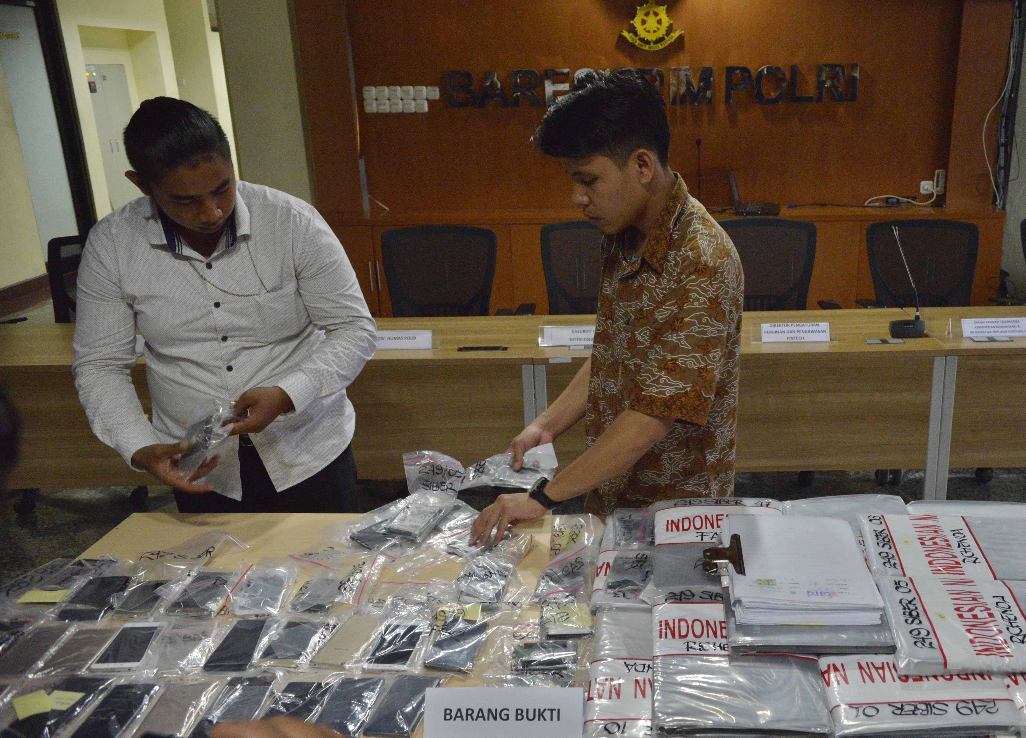  Petugas Polisi menata barang bukti asus kejahatan Fintech Ilegal di Direktorat Tindak Pidana Siber Bareskrim, Cideng