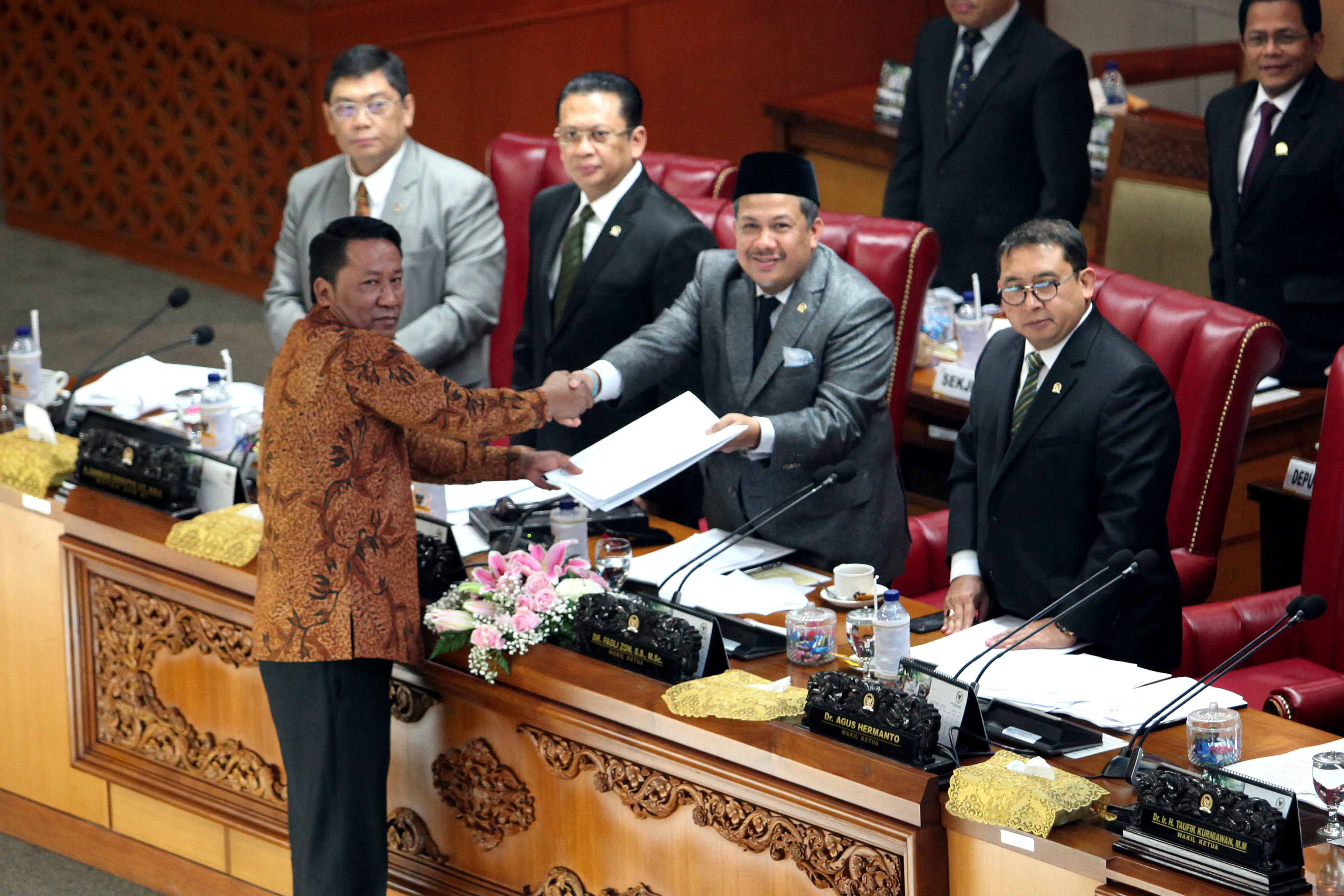 Ketua Badan Legislasi Supratman Andi Agtas (kiri) menyerahkan hasil pembahasan revisi UU KPK kepada pimpinan rapat Fahri Hamzah