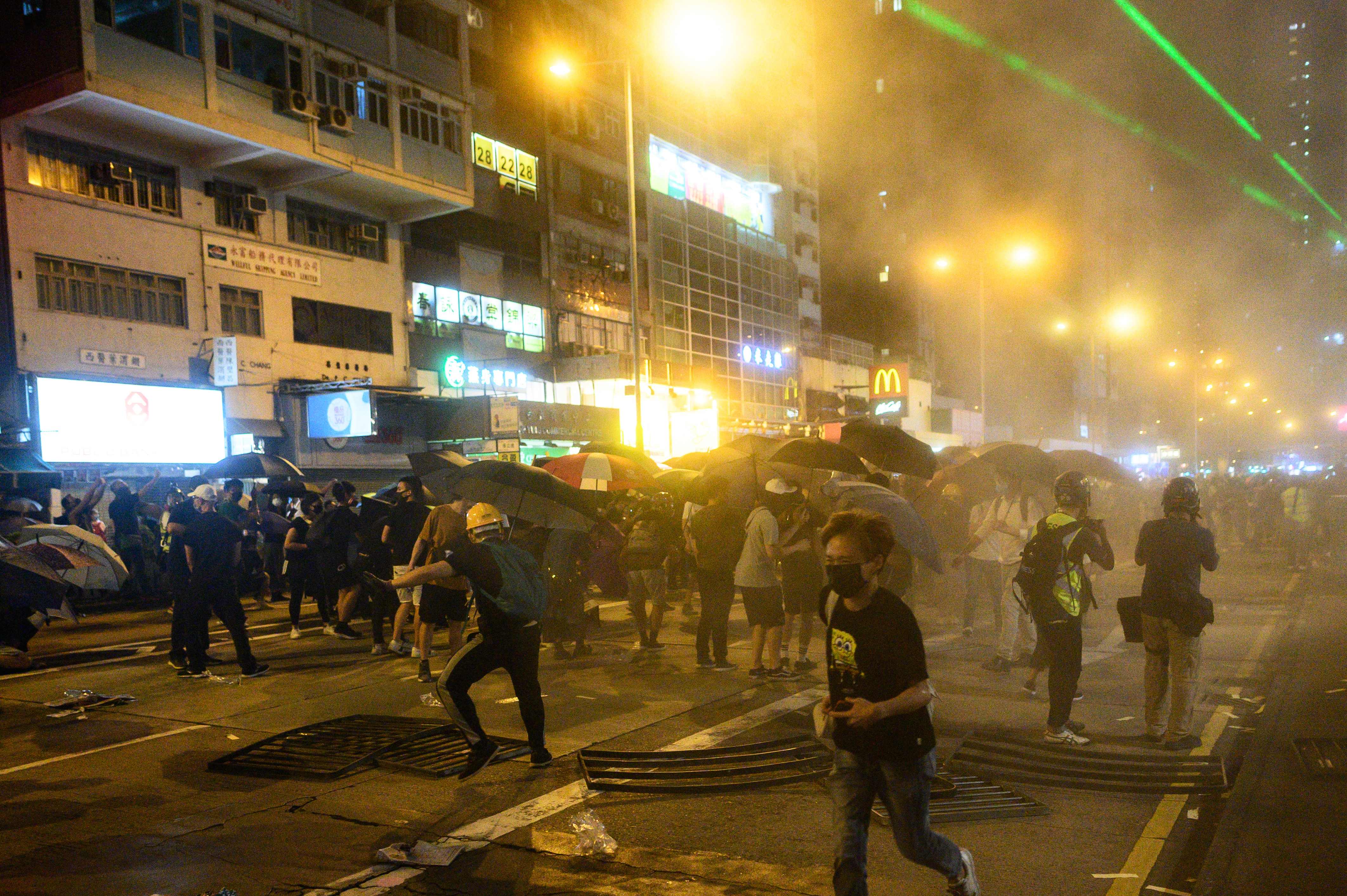 Demonstran berhamburan setelah polisi Hong Kong menembakkan gas air mata.