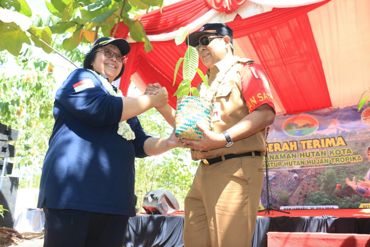 Menteri LHK Siti Nurbaya (kiri) menyerahkan bibit pohon kepada Gubernur Kalimantan Selatan Sahbirin Noor