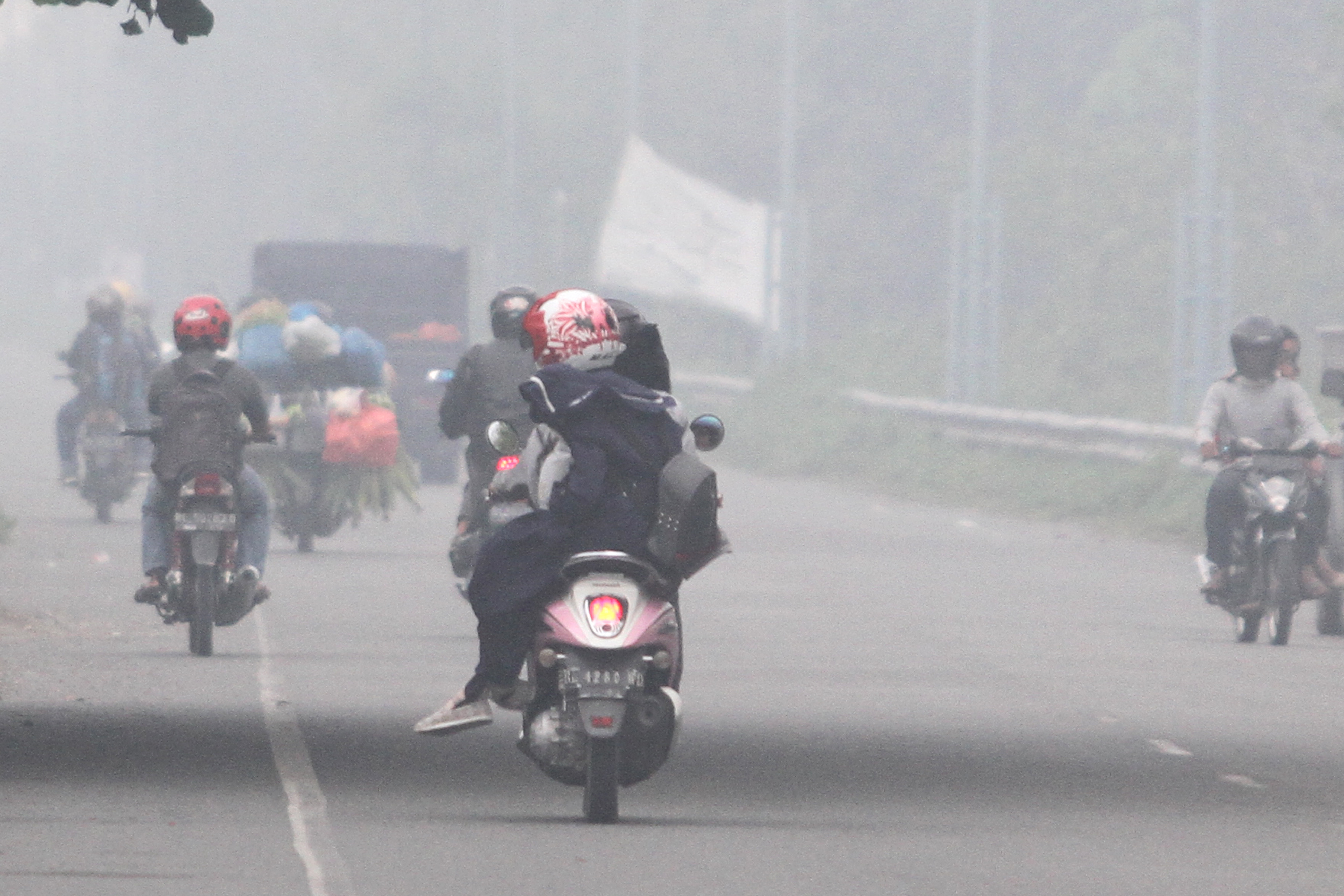 Sejumlah pengendara menembus kabut asap yang menutupi kawasan jalan lintas Nasional Medan-Banda Aceh di Desa Suak Raya