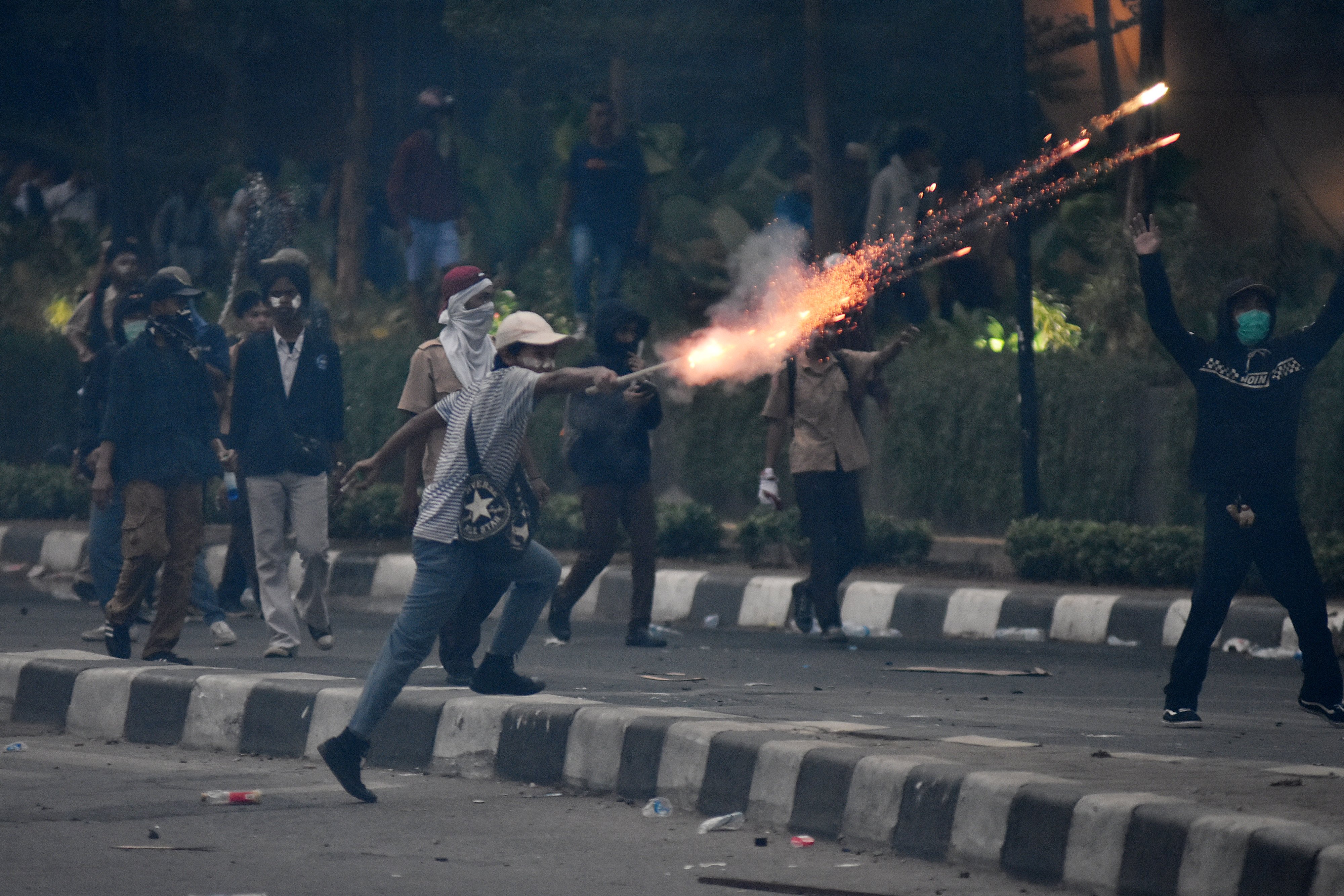 Pelajar menyulut kembang api ke arah polisi saat melakukan aksi unjuk rasa di kawasan Pejompongan, Jakarta, Rabu (25/9)