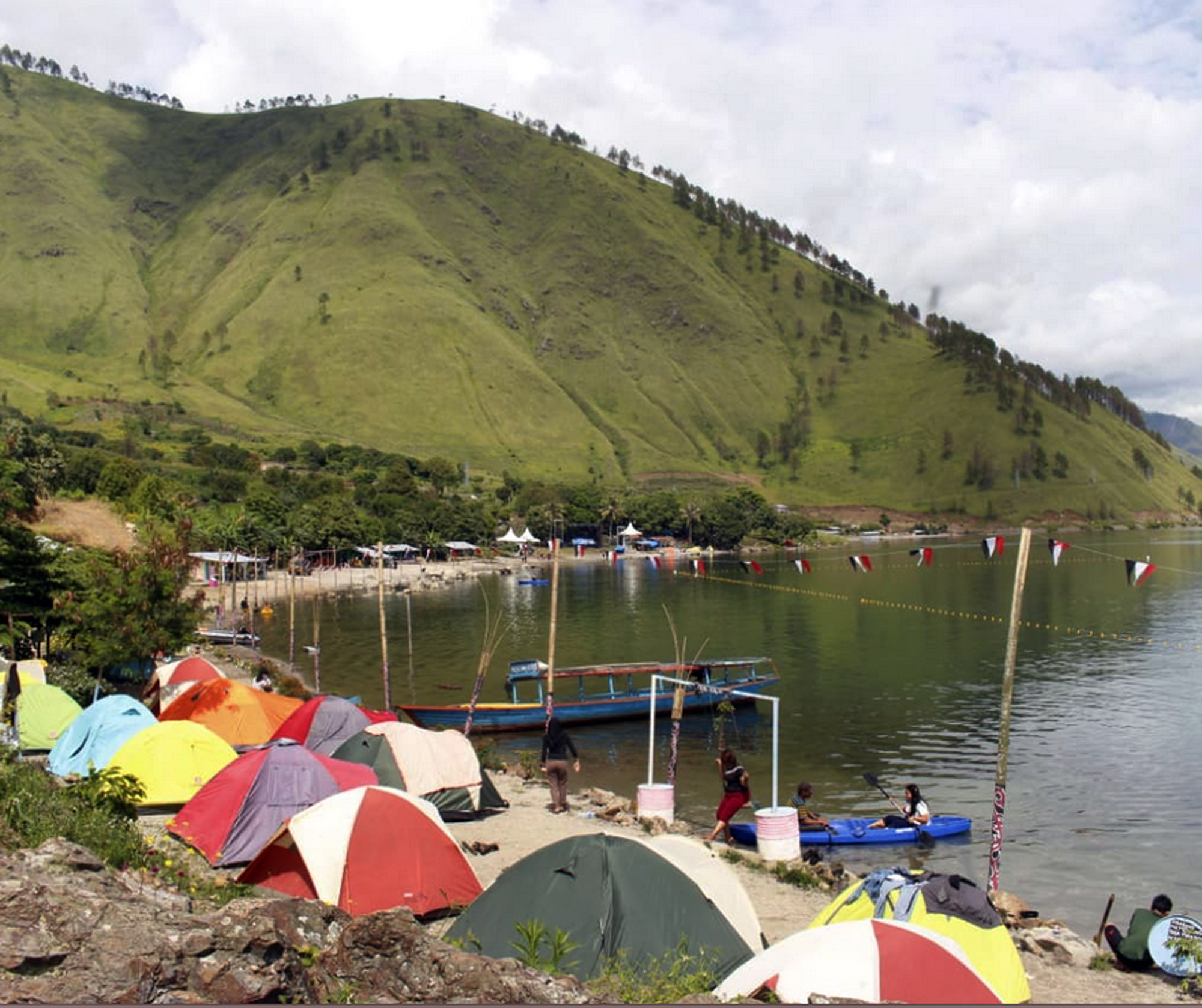 Para wisatawan mendirikan tenda di tepian danau saat Festival Danau Toba 2018 di Silahisabungan, Kabupaten Dairi, Sumatra Utara.