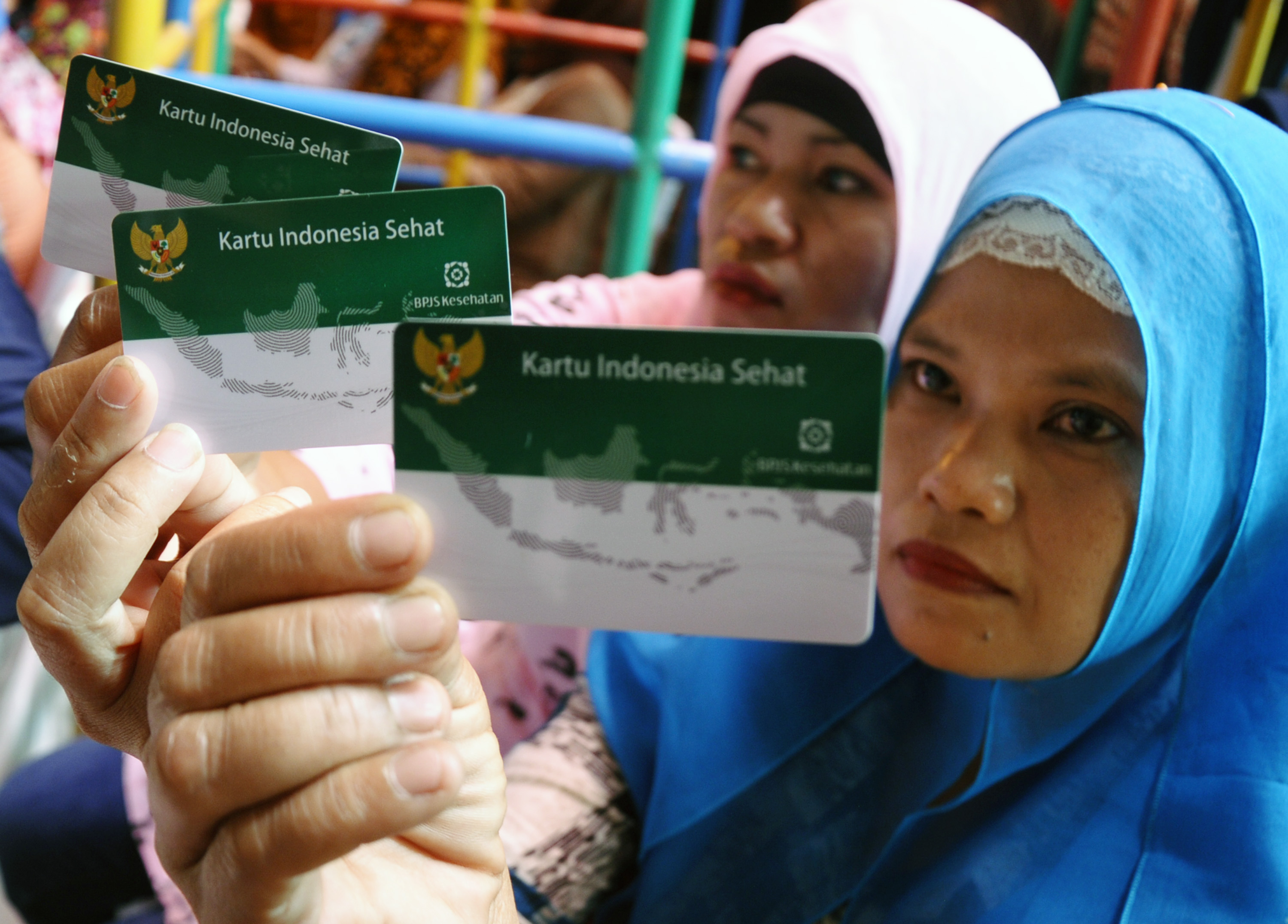 Dua orang warga menunjukkan Kartu Indonesia Sehat.
