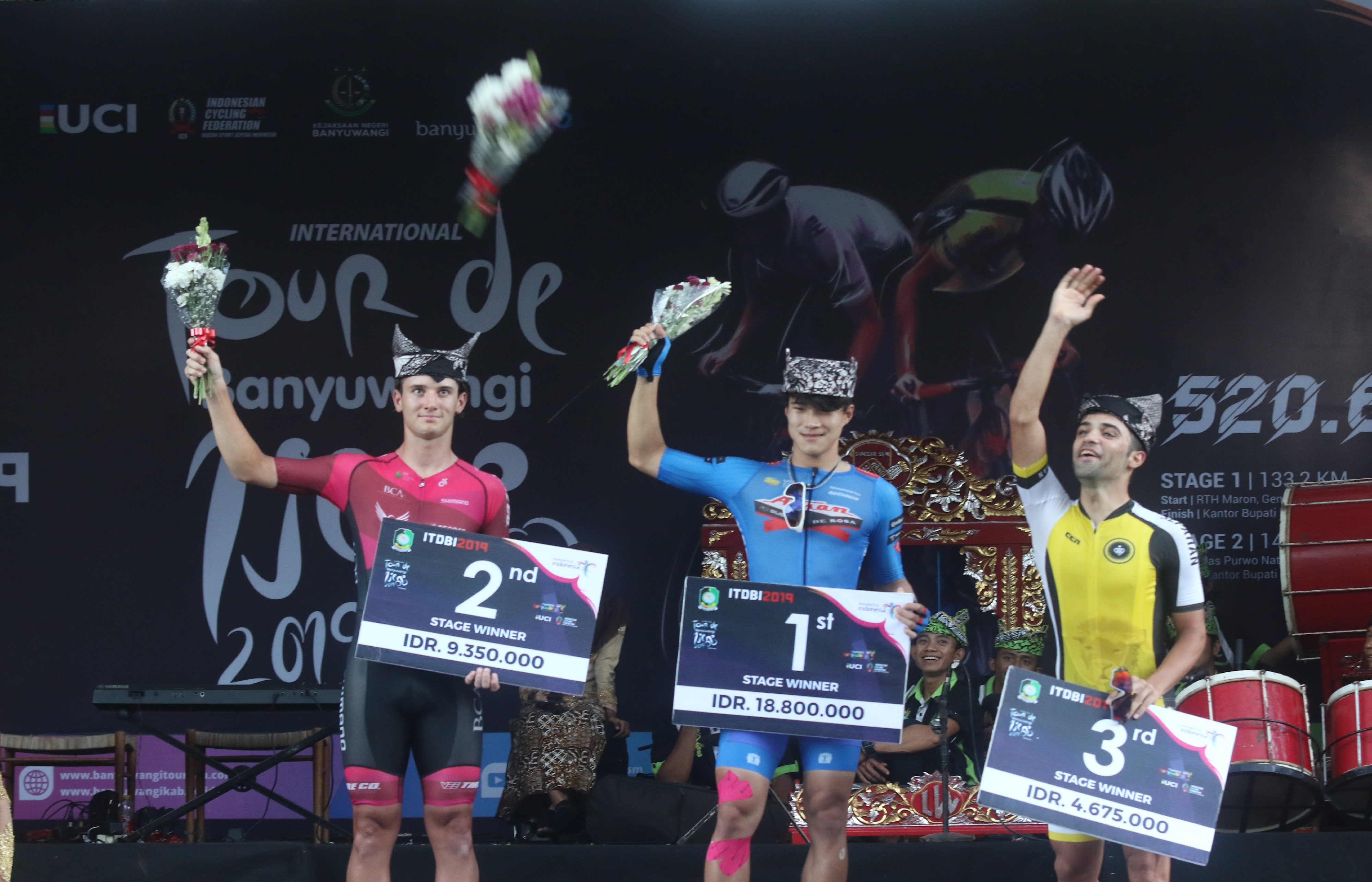 Pebalap sepeda Aisan Racing Team Omae Kakeru (tengah) menaiki podium setelah menjadi juara pertama.