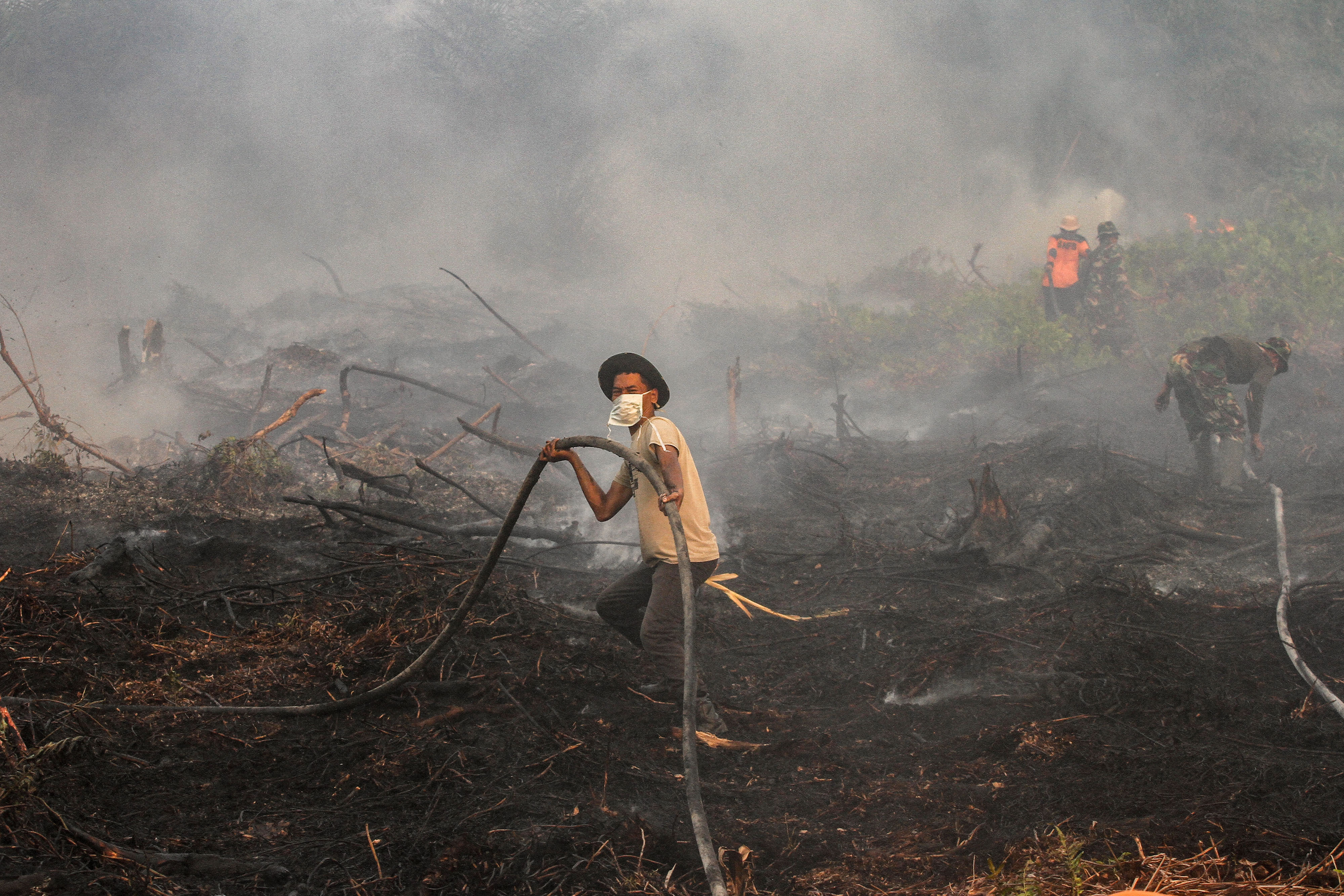 Petugas gabungan dari BPBD Pekanbaru, Kodim 0301 Pekanbaru dan MPA berusaha memadamkan kebakaran lahan gambut di Pekanbaru, Riau.