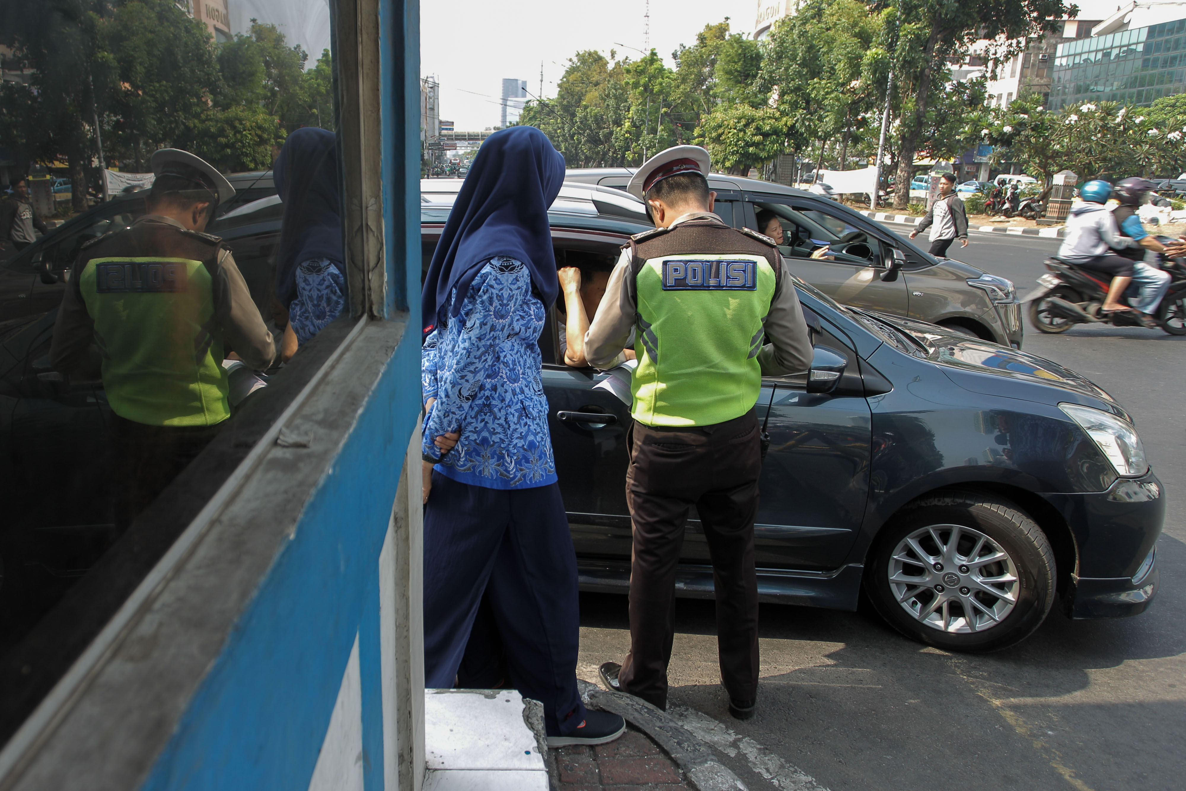 Polisi melakukan penindakan berupa penilangan terhadap pengemudi yang melanggar kebijakan perluasan ganjil-genap