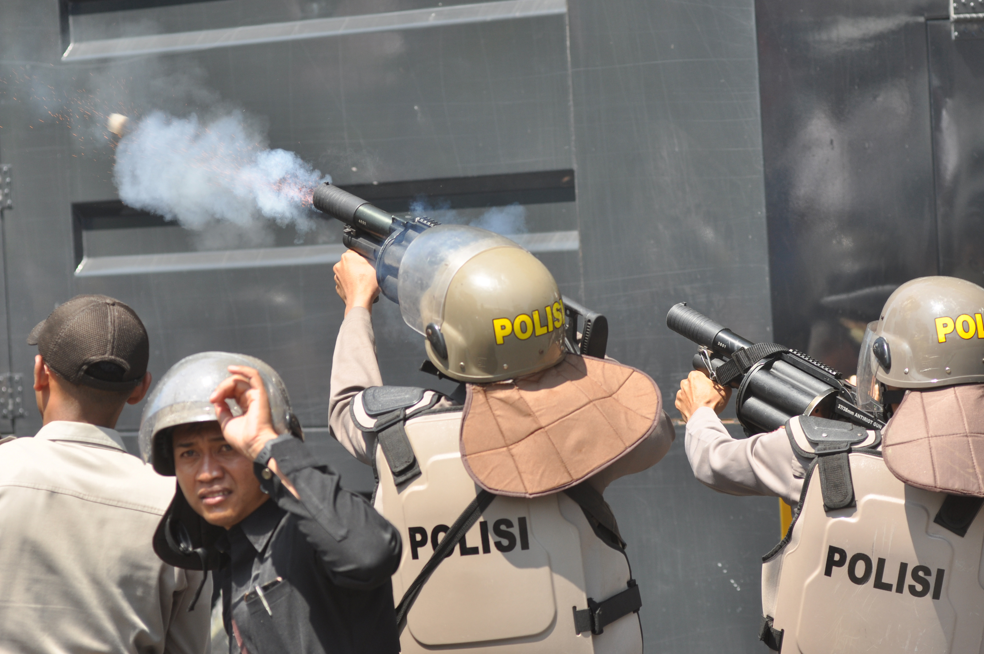 Polisi menembak gas air mata dalam unjuk rasa menolak UU KPK dan RUU KUHP di Jalan Samratulangi Palu, Sulawesi Tengah, kemarin.