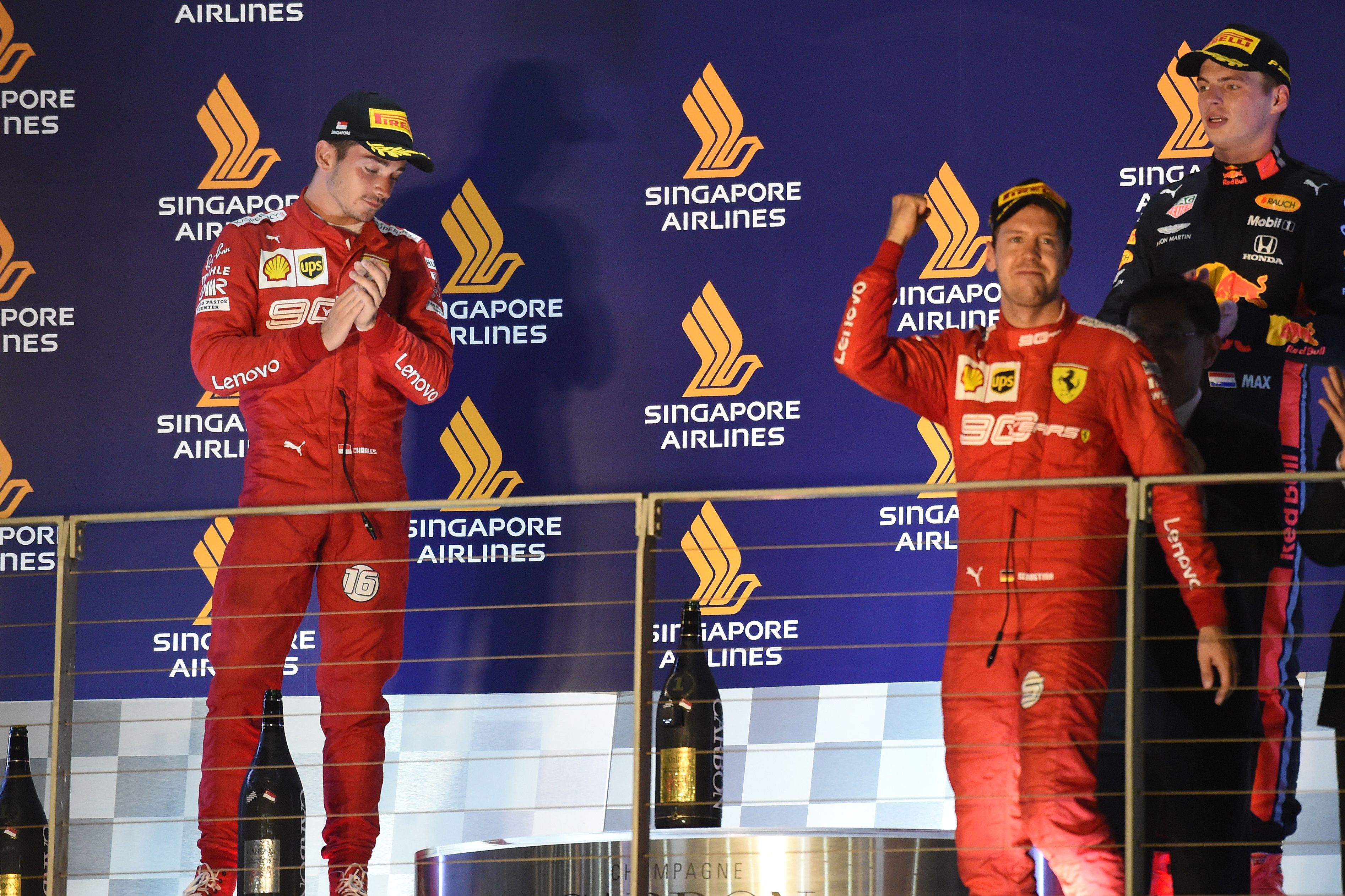 Pembalap Ferrari Monegasque yang berada di posisi kedua Charles Leclerc (kiri) menatap podium saat pembalap Ferrari asal Jerman Sebastian Ve