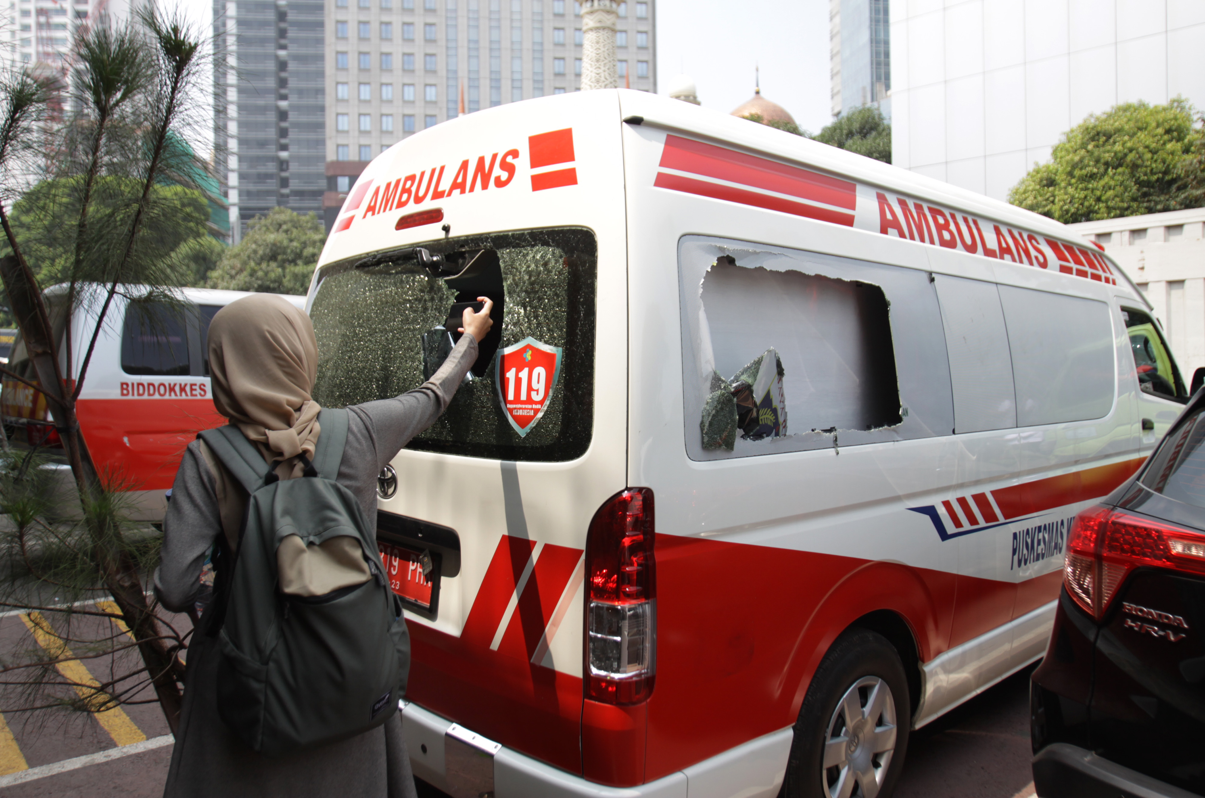 Wartawan mengambil gambar mobil ambulans milik Pemprov DKI Jakarta yang ditahan di Halaman Polda Metro Jaya, Jakarta. 