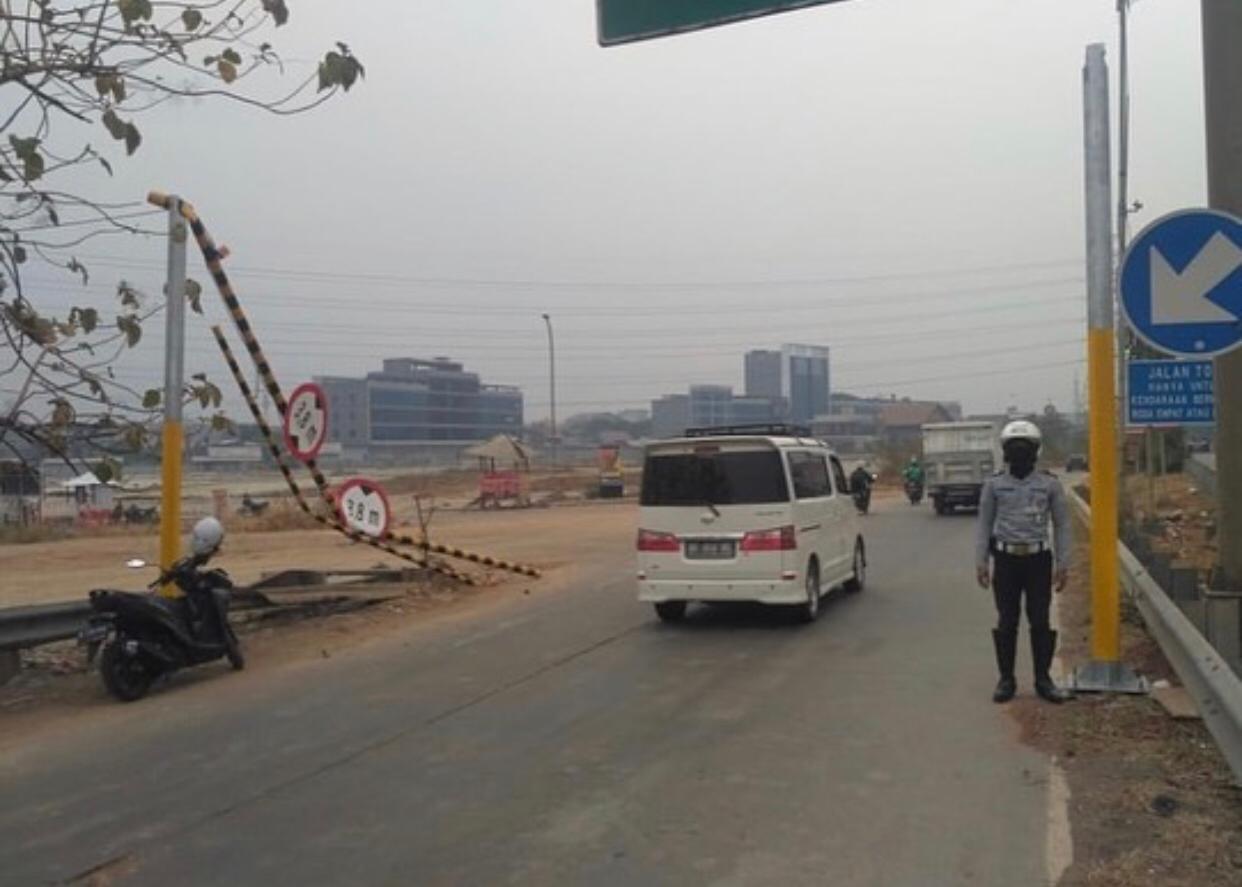Petugas di portal pembatas tinggi kendaraan di pintu keluar tol Kalimalang yang kembali rusak. 