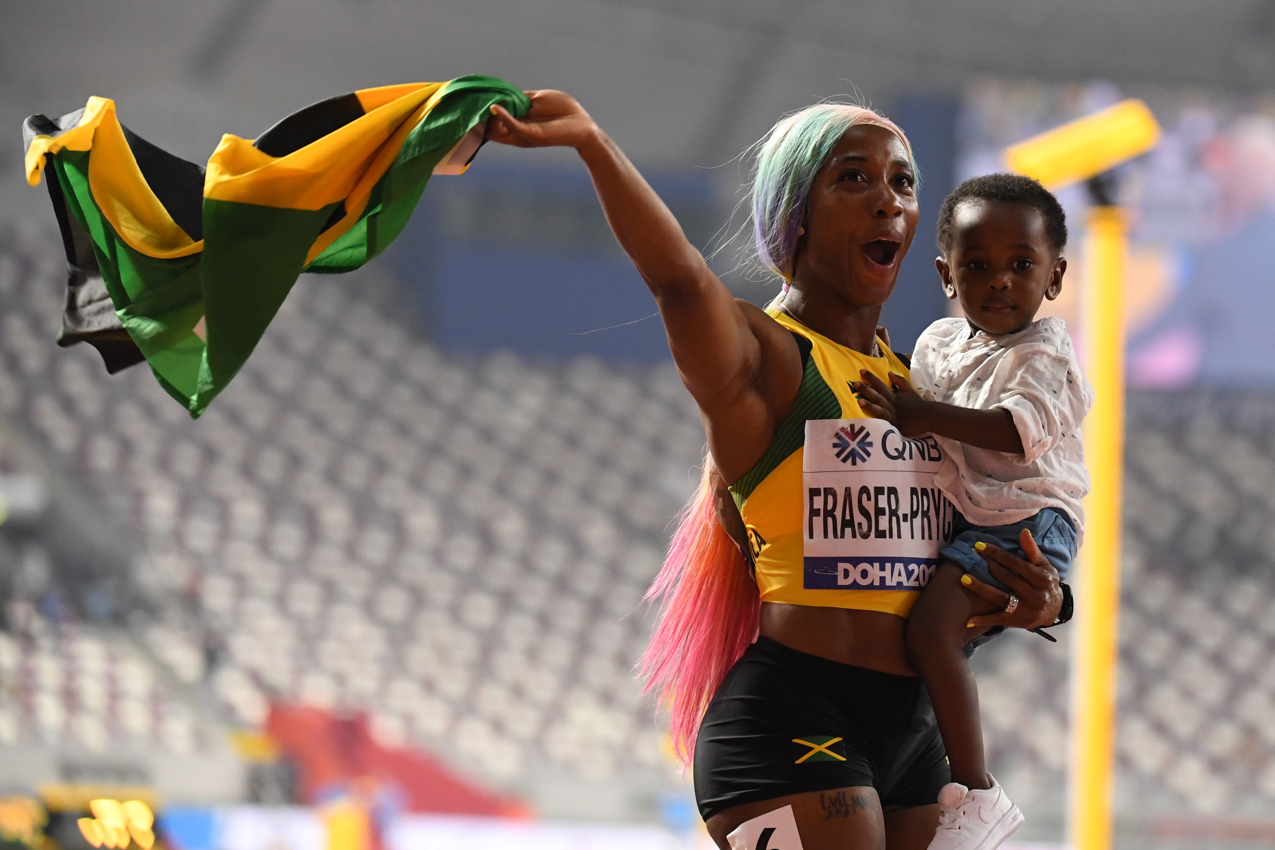 Shelly-Ann Fraser-Pryce merayakan keberhasilannya menjadi juara dunia lari 100 meter bersama putranya, Zyon.