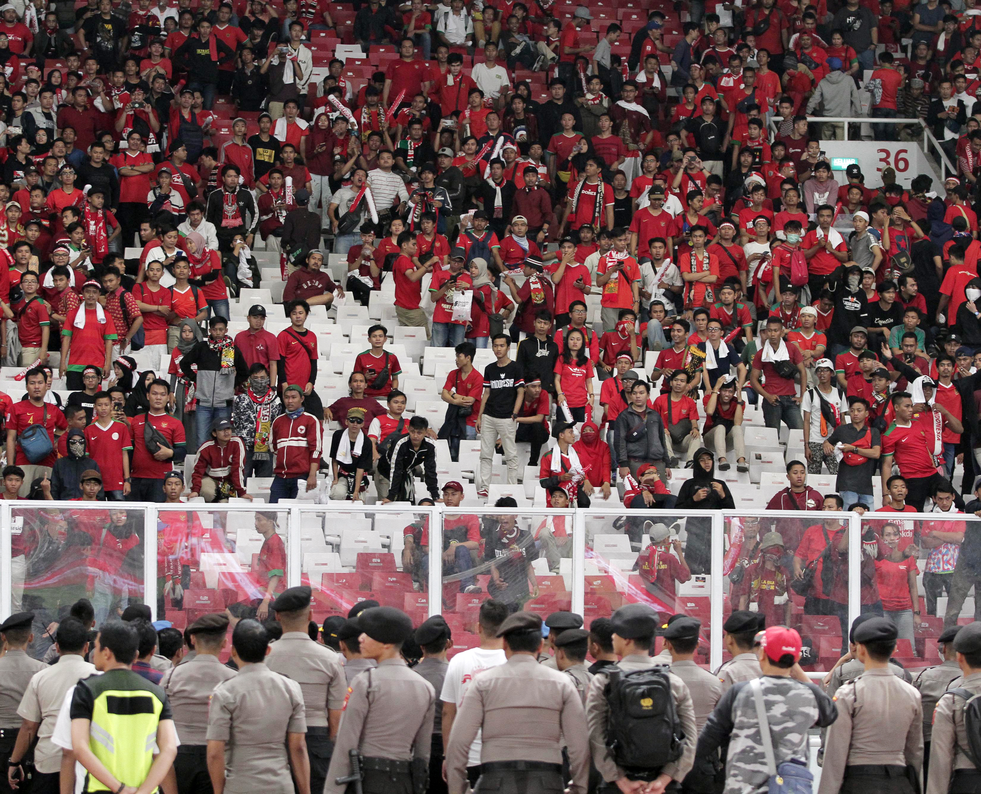 Petugas Kepolisian mengamankan suporter saat pertandingan sepakbola Indonesia melawan Malaysia pada kualifikasi Piala Dunia 2022.