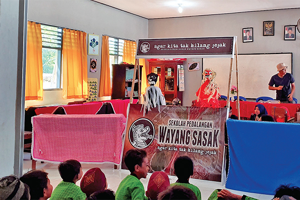 Sejumlah anak dari SD Negeri 47 Ampenan Kota Mataram, Lombok, terlihat gembira menyaksikan pertunjukan wayang sasak