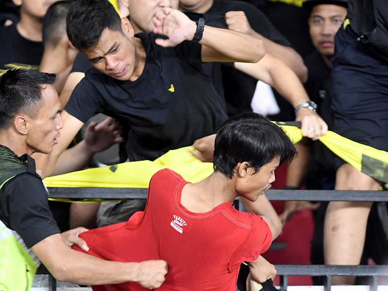 Seorang suporter Indonesia (bawah) berusaha menyerang suporter Malaysia saat pertandingan timnas Indonesia melawan timnas Malaysia 