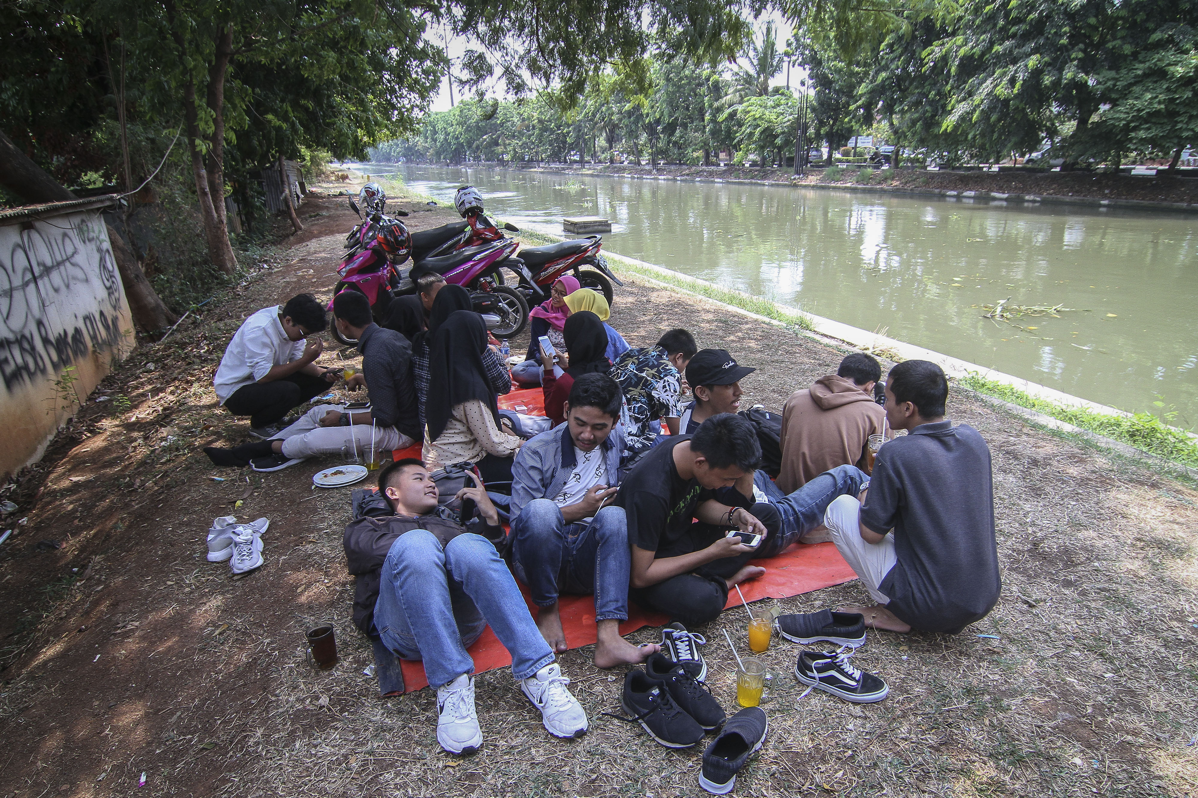 Sejumlah mahasiswa beristirahat di bantaran Kalimalang, Bekasi, Jawa Barat