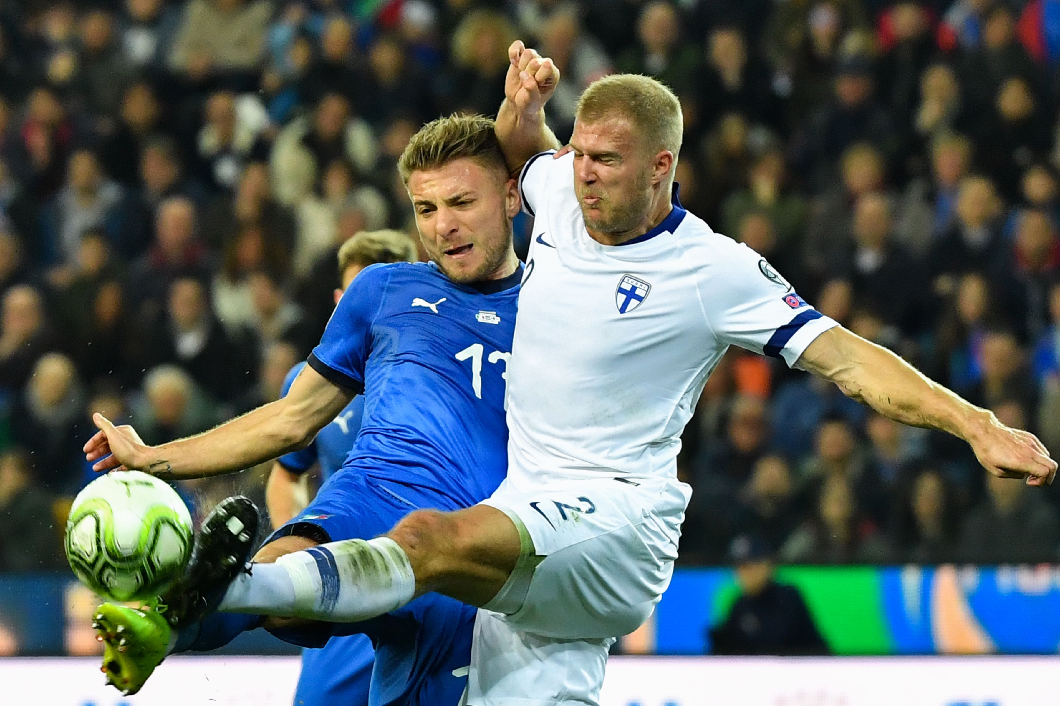 Striker Italia Ciro Immobile (kiri) berduel dengan pemain belakang Finlandia Paulus Arajuuri 