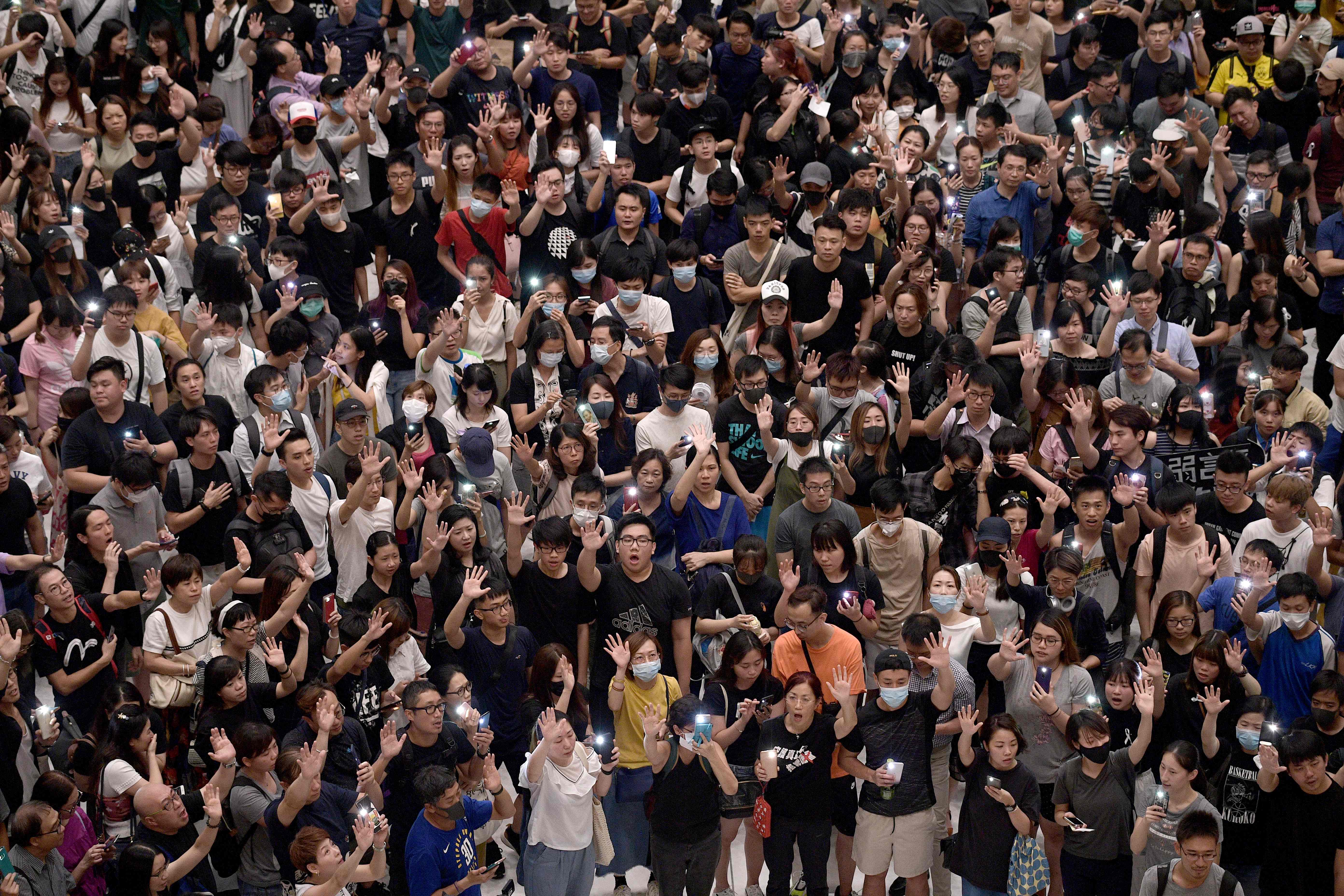 Demonstran berkumpul di sebuah mal di Shatin, Hong Kong menyanyikan lagu tema Glory to Hong Kong.