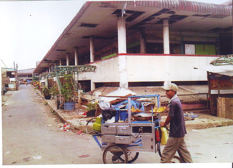 Seorang pedagang melintas di Pasar Cisalak yang terbengkalai, di Cimanggis, Depok