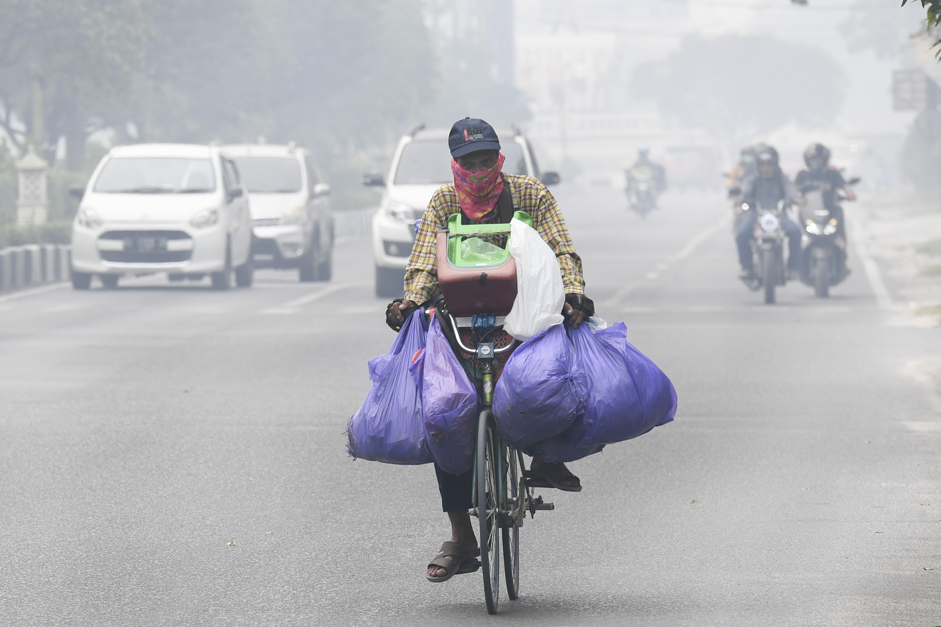  Warga menggunakan masker saat mengendarai sepeda di Palangka Raya, Kalimantan Tengah, Jumat (20/9)