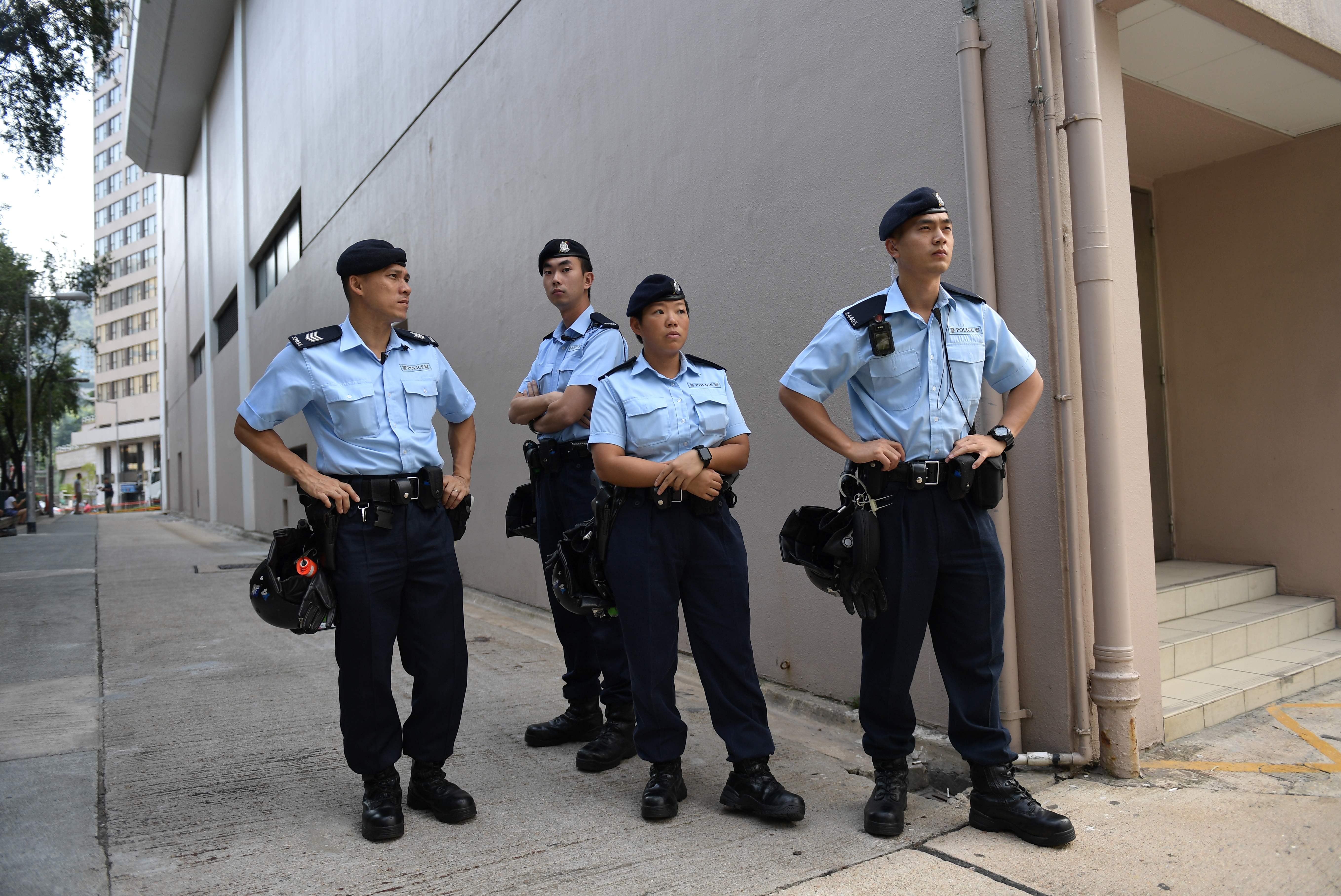 Polisi Hong Kong berjaga di luar Stadiun Queen Elizabeth jeleng pertemuan Kepala Eksekutif Hong Kong Carry Lam dan 150 warga. 