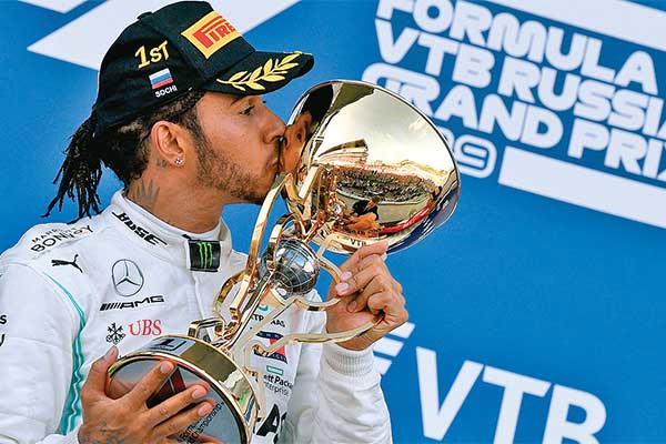 Pembalap tim Mercedes, Lewis Hamilton, mencium trofi juara setelah menjadi kampiun balap Formula 1 GP Rusia di Sirkuit Sochi Autodrom
