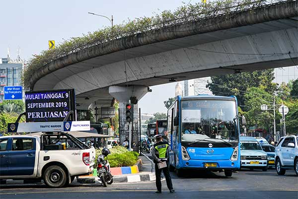 Petugas kepolisian mengatur lalulintas saat hari pertama penindakan sistem ganjil-genap di kawasan Matraman, Jakarta, Senin (9/9/2019).