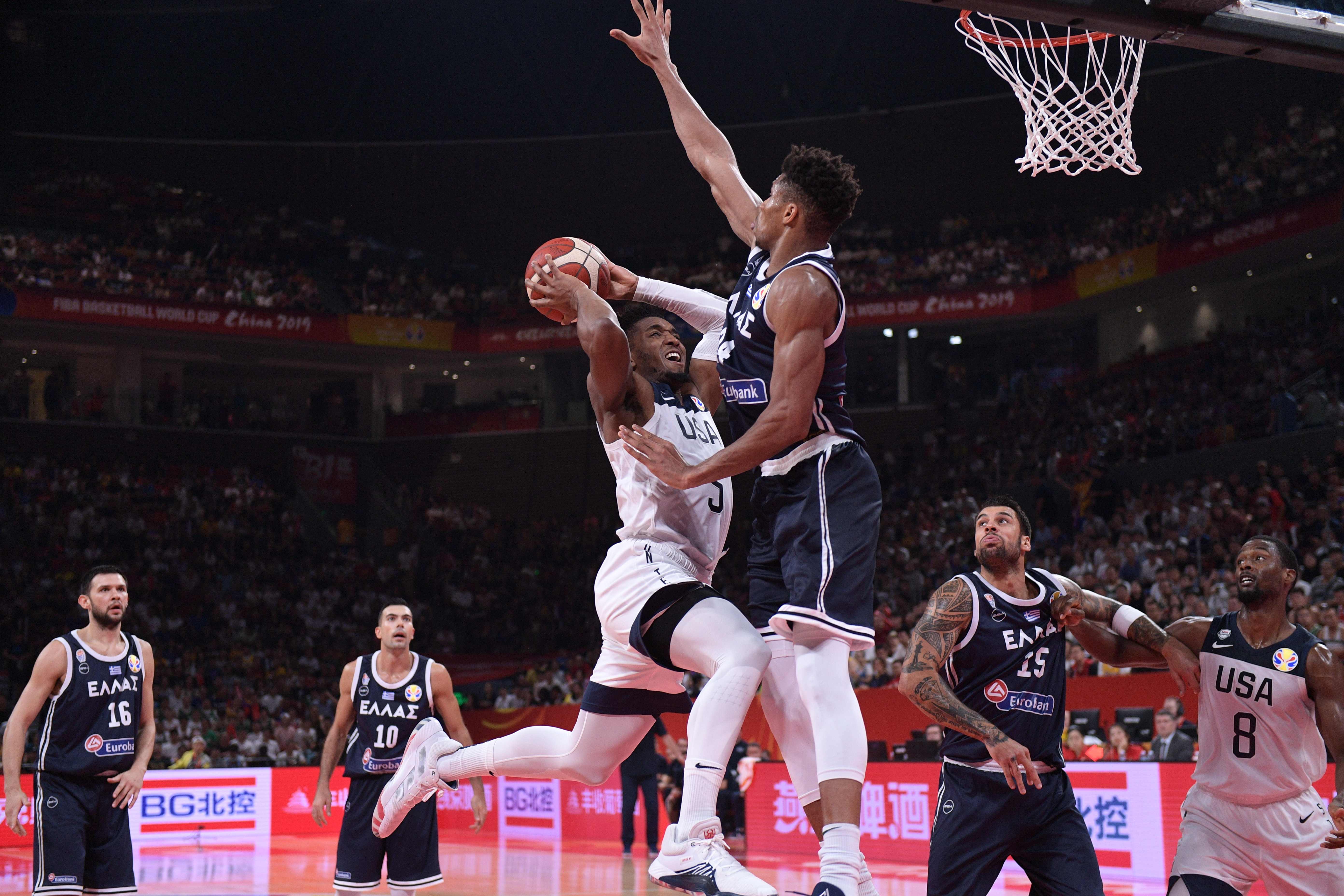 Bintang Yunani Giannis Antetokounmpo berusaha menghalangi upaya pemain AS Donovan Mitchell mencetak poin.