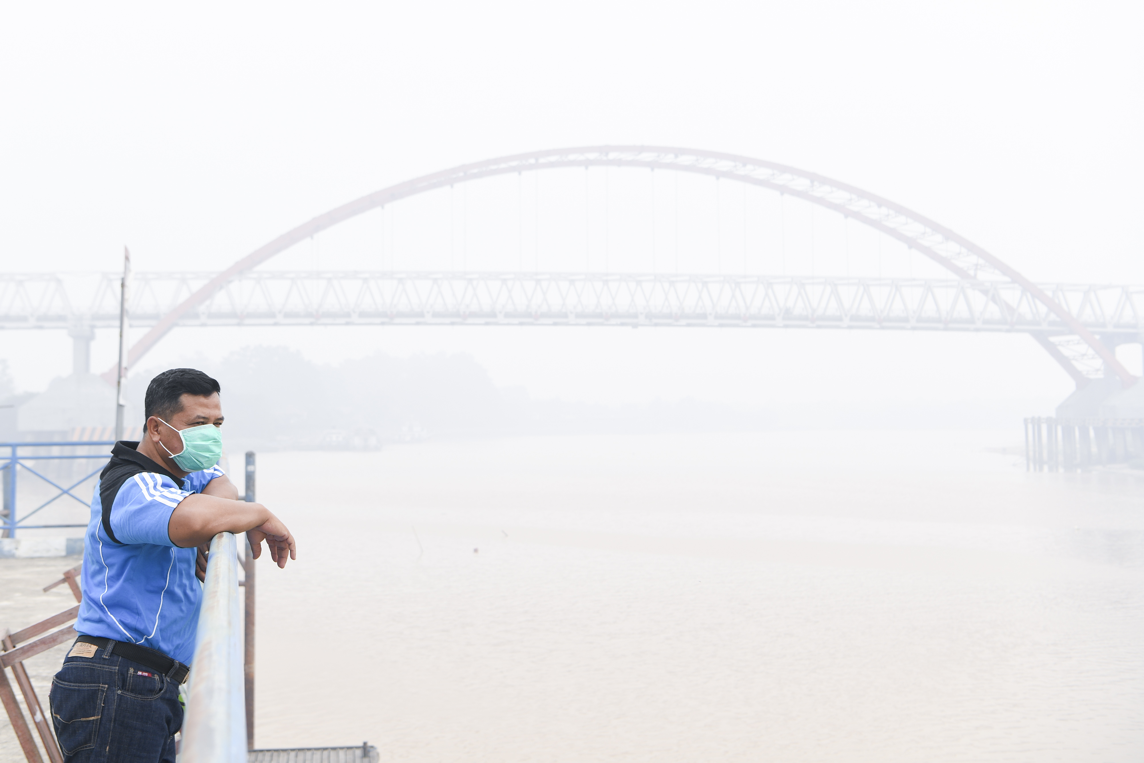 Warga menggunakan masker saat memandangi Sungai Kahayan di Palangka Raya, Kalimantan Tengah, Jumat (20/9).