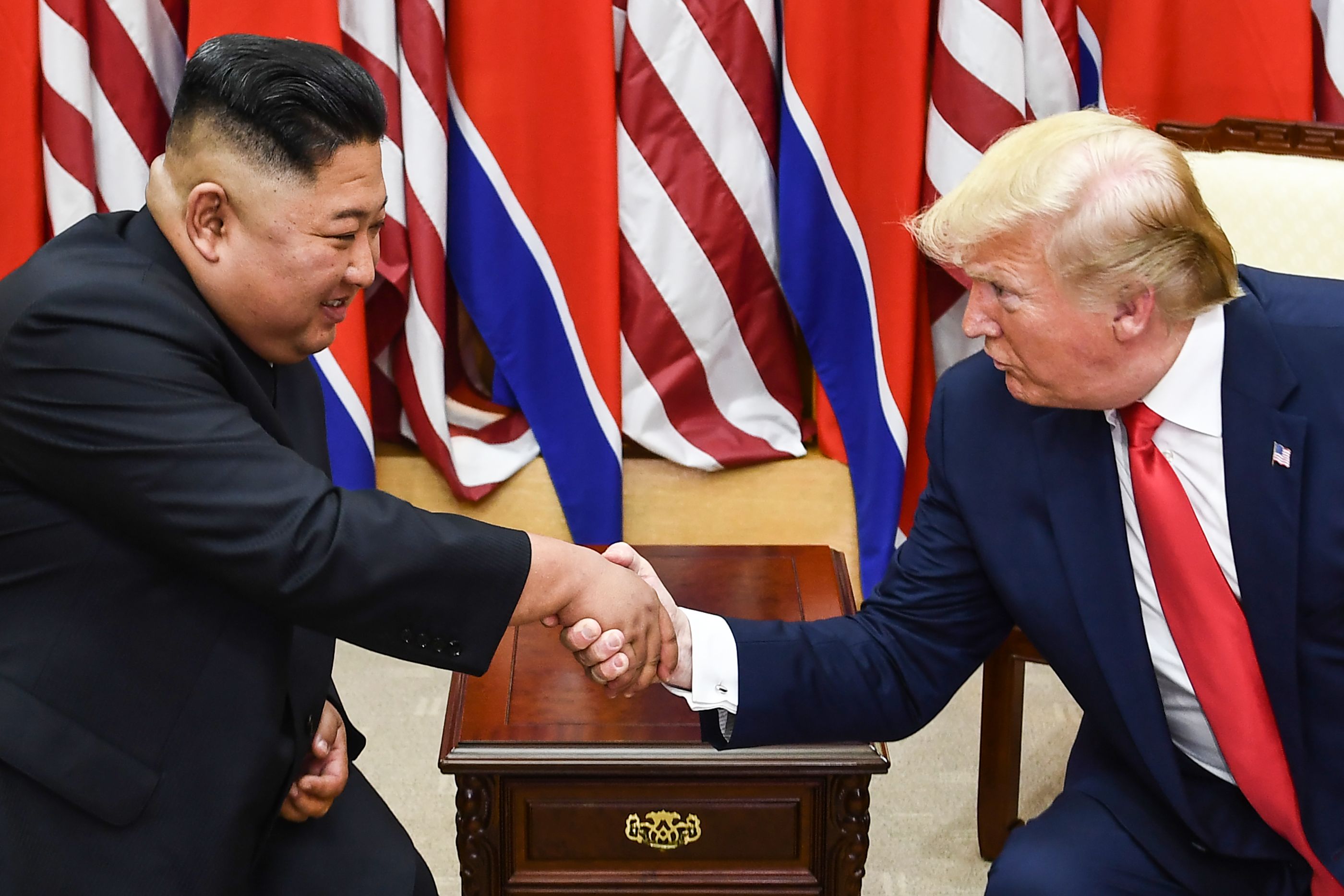 Pemimpin Koresa Utara Kim Jong-un (kiri) berjabat tangan dengan Presiden Amerika Serikat (AS) Donald Trump