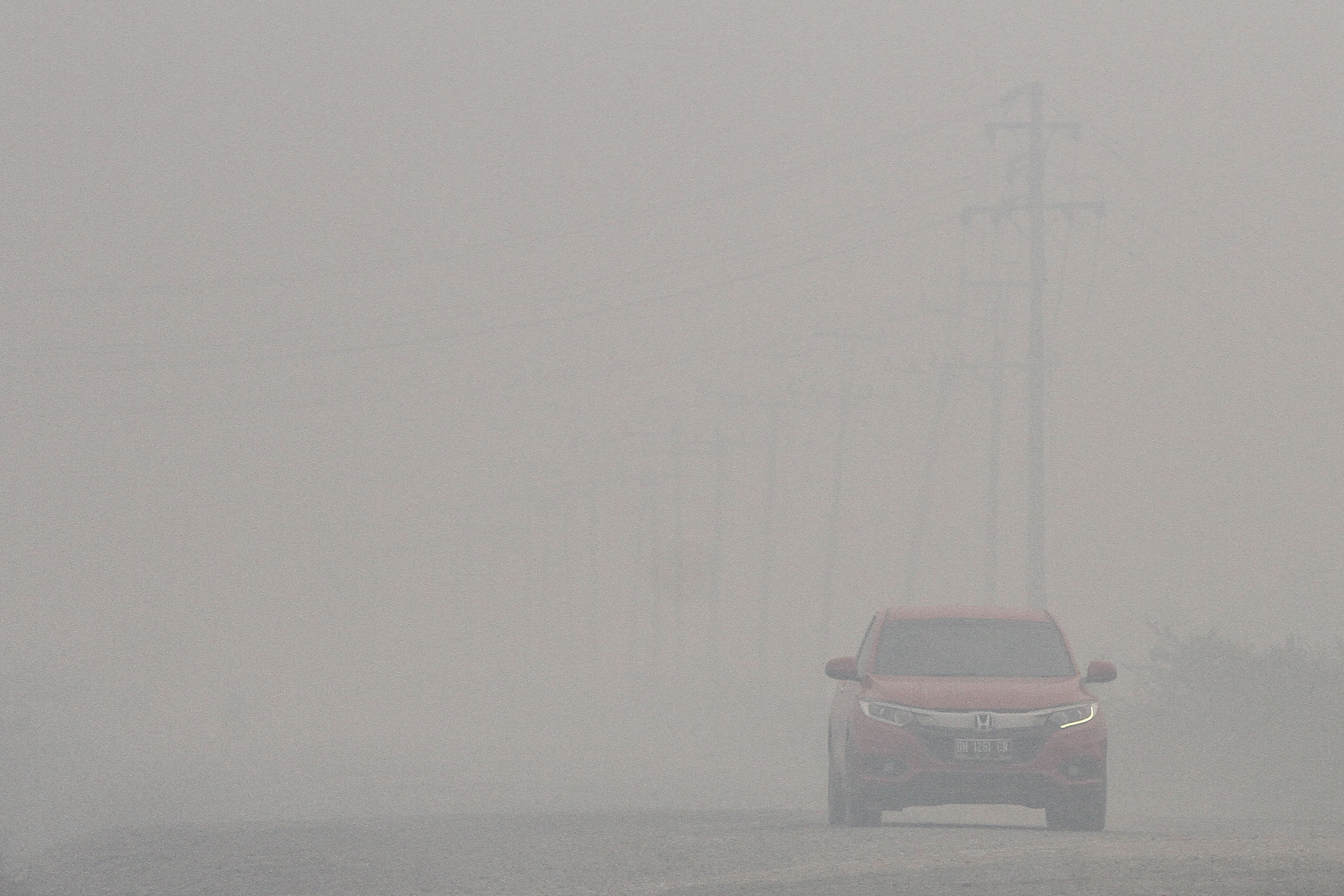  Pengendara kendaraan bermotor menembus kabut asap pekat ketika terjadi kebakaran lahan di Kabupaten Pelalawan, Riau, Kamis (19/9/2019).