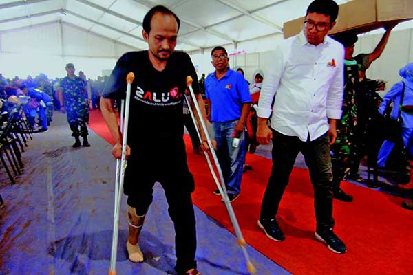 Ketua Harian Yayasan Kick Andy Foundation, Ali Sadikin (kanan), mengajarkan Idrus Berlian menggunakan kaki palsu di Rancamanyar, Bandung.