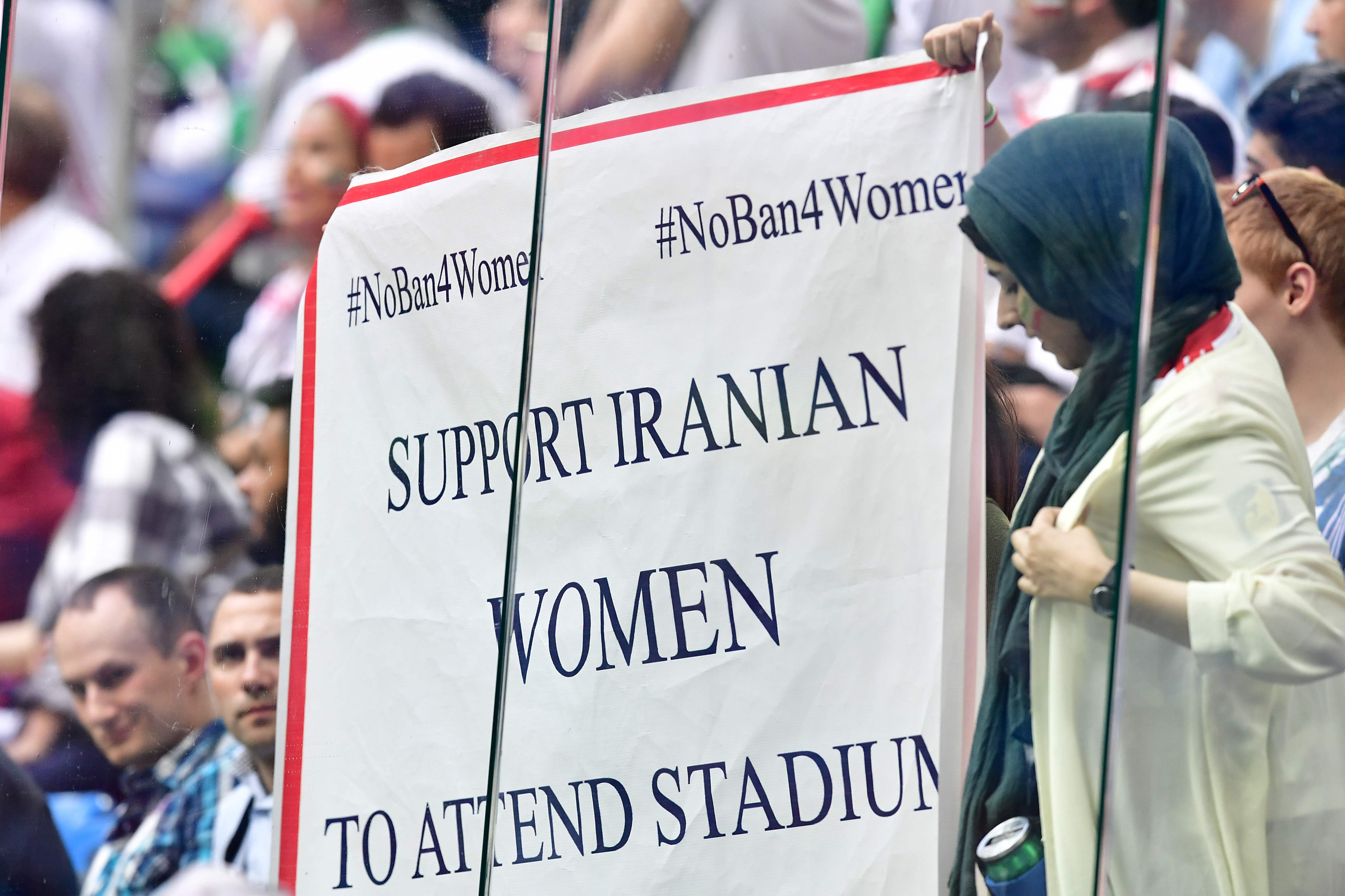 Seorang perempuan membawa spanduk seruan agar Iran mengizinkan perempuan menonton bola di Stadion saat Piala Dunia 2018.