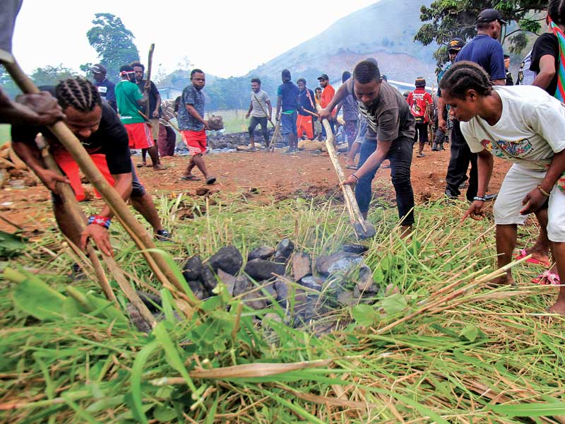Masyarakat Papua melakukan upacara bakar batu di lapangan Hawai, Sentani, Papua, Kamis (5/9). 