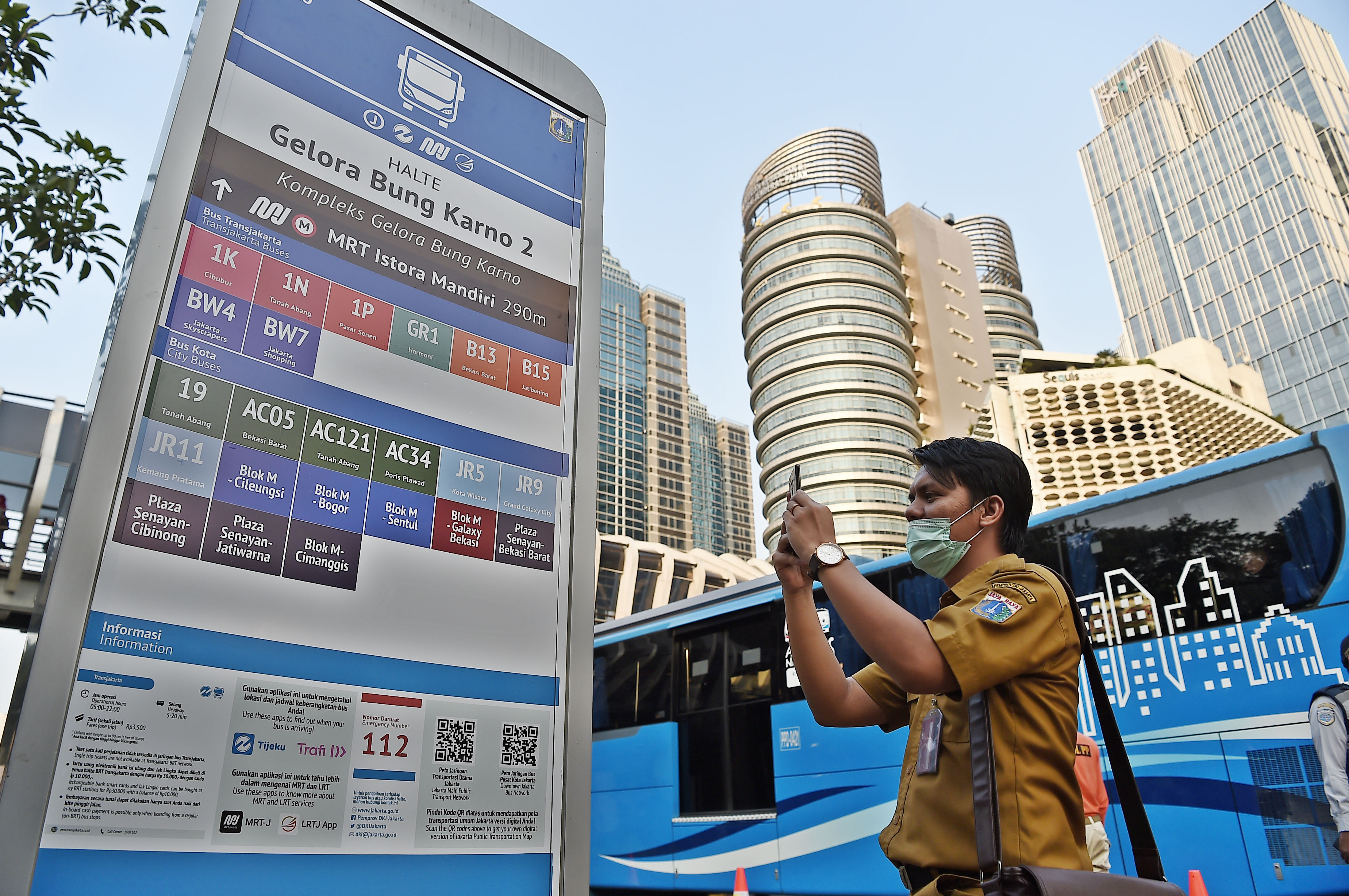 Warga memotret media informasi moda transportasi publik di Halte Gelora Bung Karno, Jakarta, Selasa (13/8).