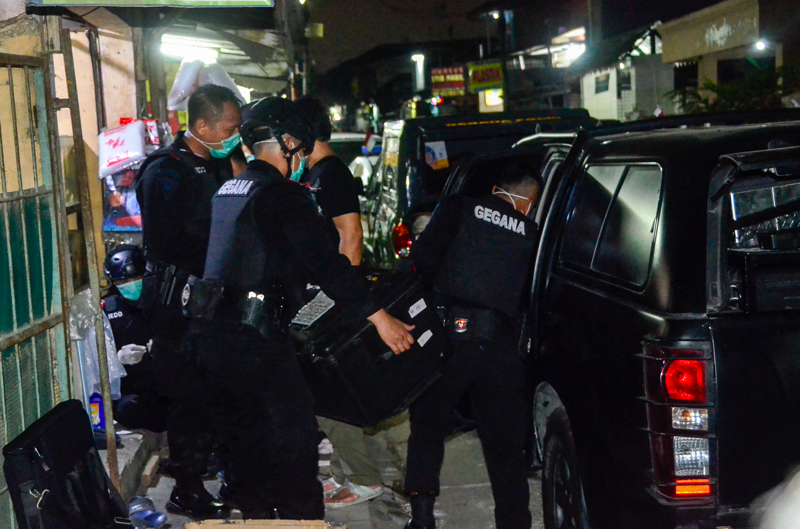 Personel Gegana Korps Brimob Polri membawa barang saat bersama Tim Densus 88 menggeledah rumah terduga teroris di Desa Setia Mekar, Bekasi.