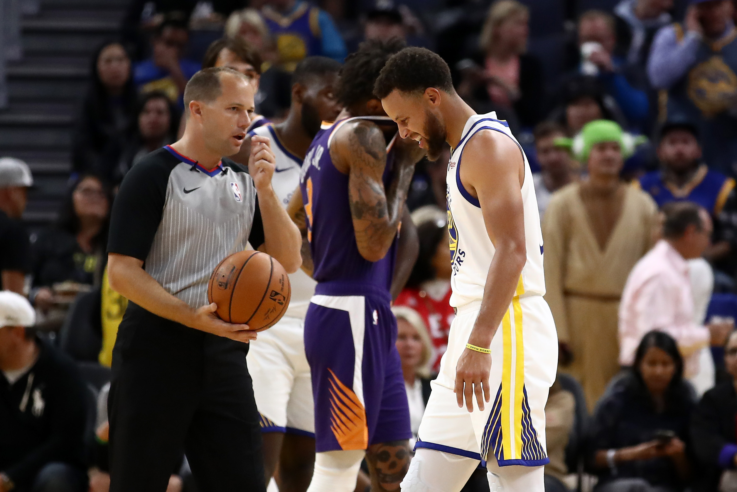 Bintang Warriors Stephen Curry terlihat kesakitan saat meninggalkan lapangan dalam laga NBA melawan Suns.