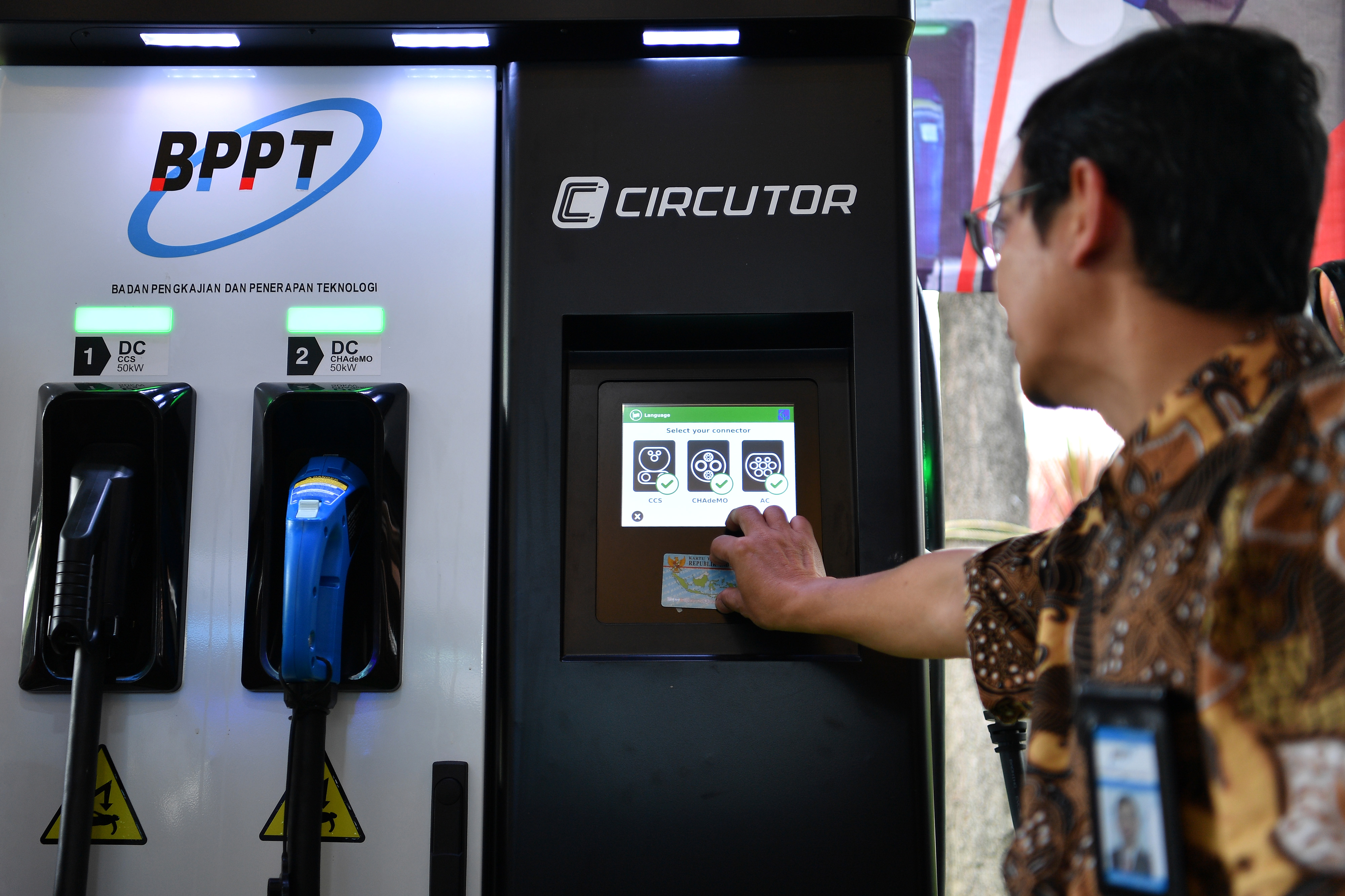 Petugas mendemonstrasikan cara pengisian kendaraan listrik di Electric Vehicle Charging Station (EVCS) di kantor BPPT, Jakarta