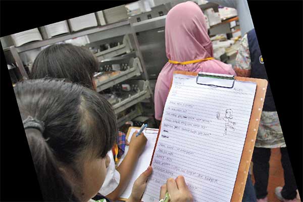 Repcil mendengarkan dan mencatat informasi saat berkunjung ke dapur McDonald’s.