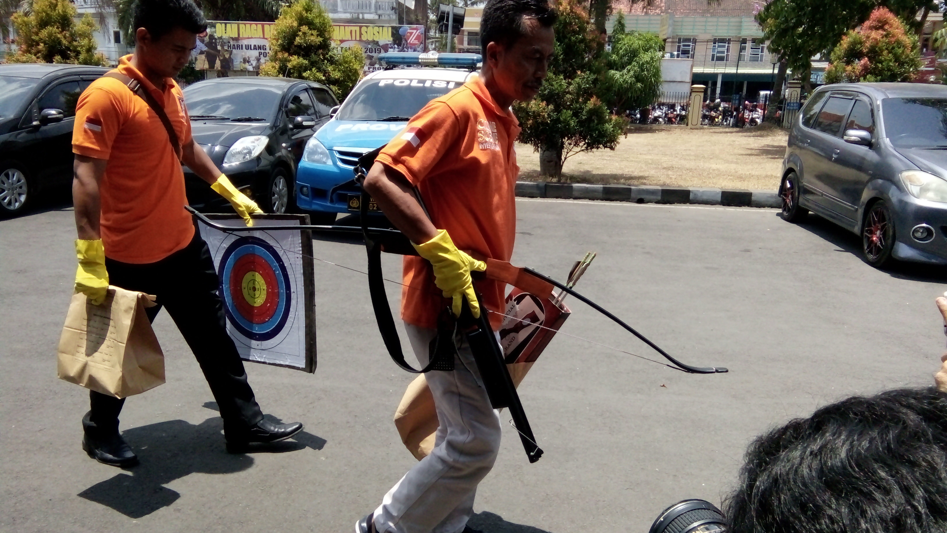 Anggota Polres Tasikmalaya membawa panah dan papan target yang didapat dari penggeledahan di ruang kerja W di Gardu Induk PLN. 