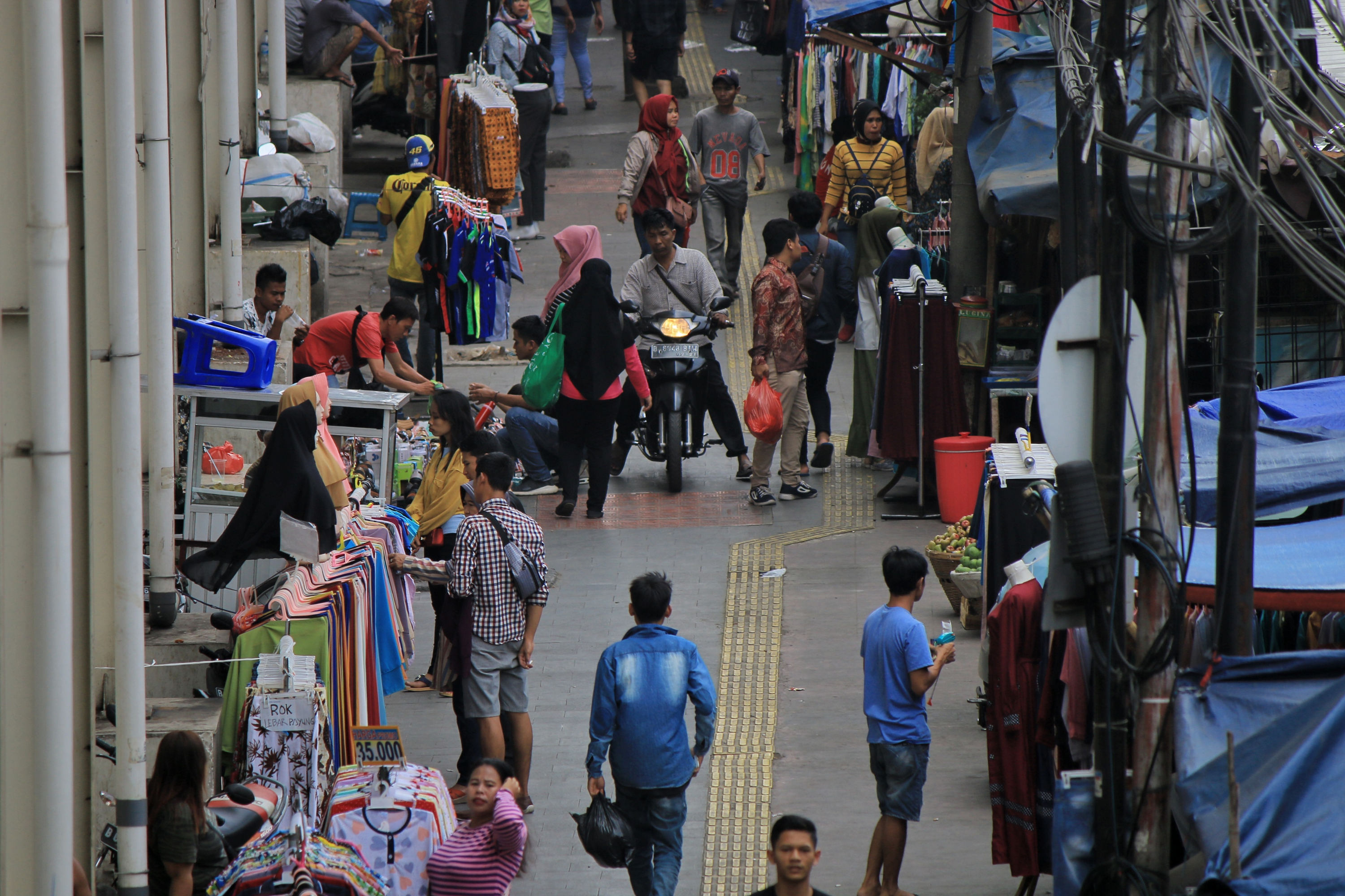 Pedagang kaki lima (PKL) berjualan di trotoar jembatan penyeberangan multiguna (skybridge) Tanah Abang, Jakarta