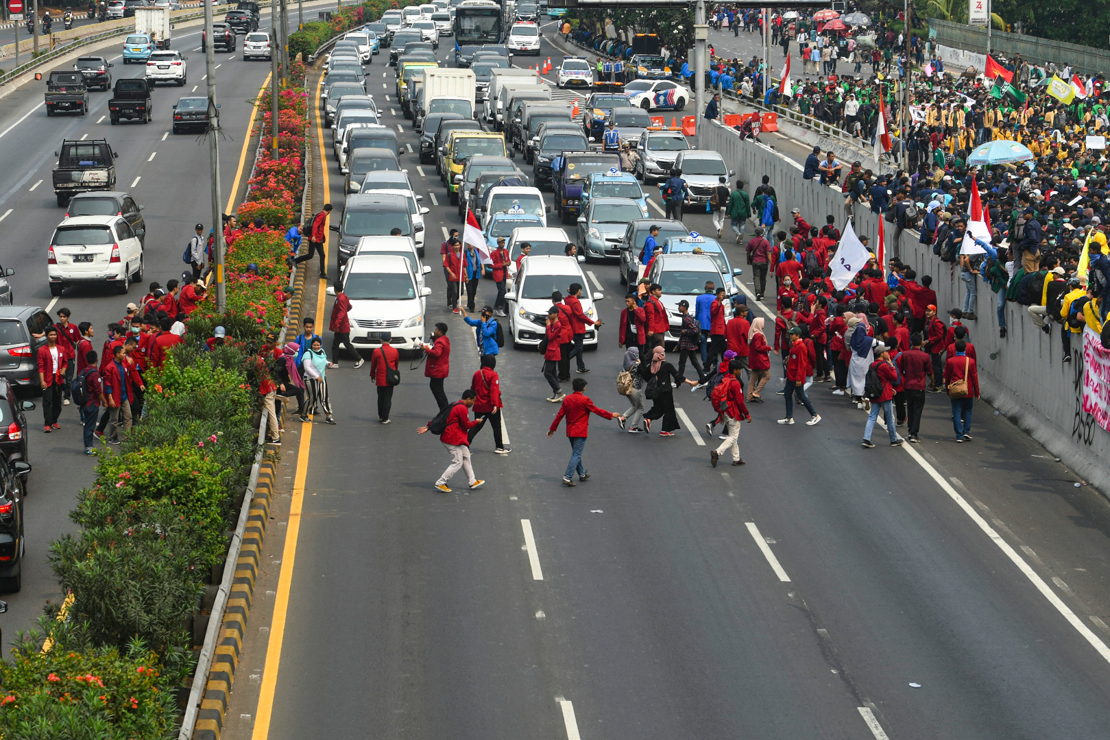 Mahasiswa menyeberangi jalan Tol Dalam Kota untuk mengikuti aksi unjuk rasa di depan kompleks Parlemen, Senayan, Jakarta, Selasa (24/9)