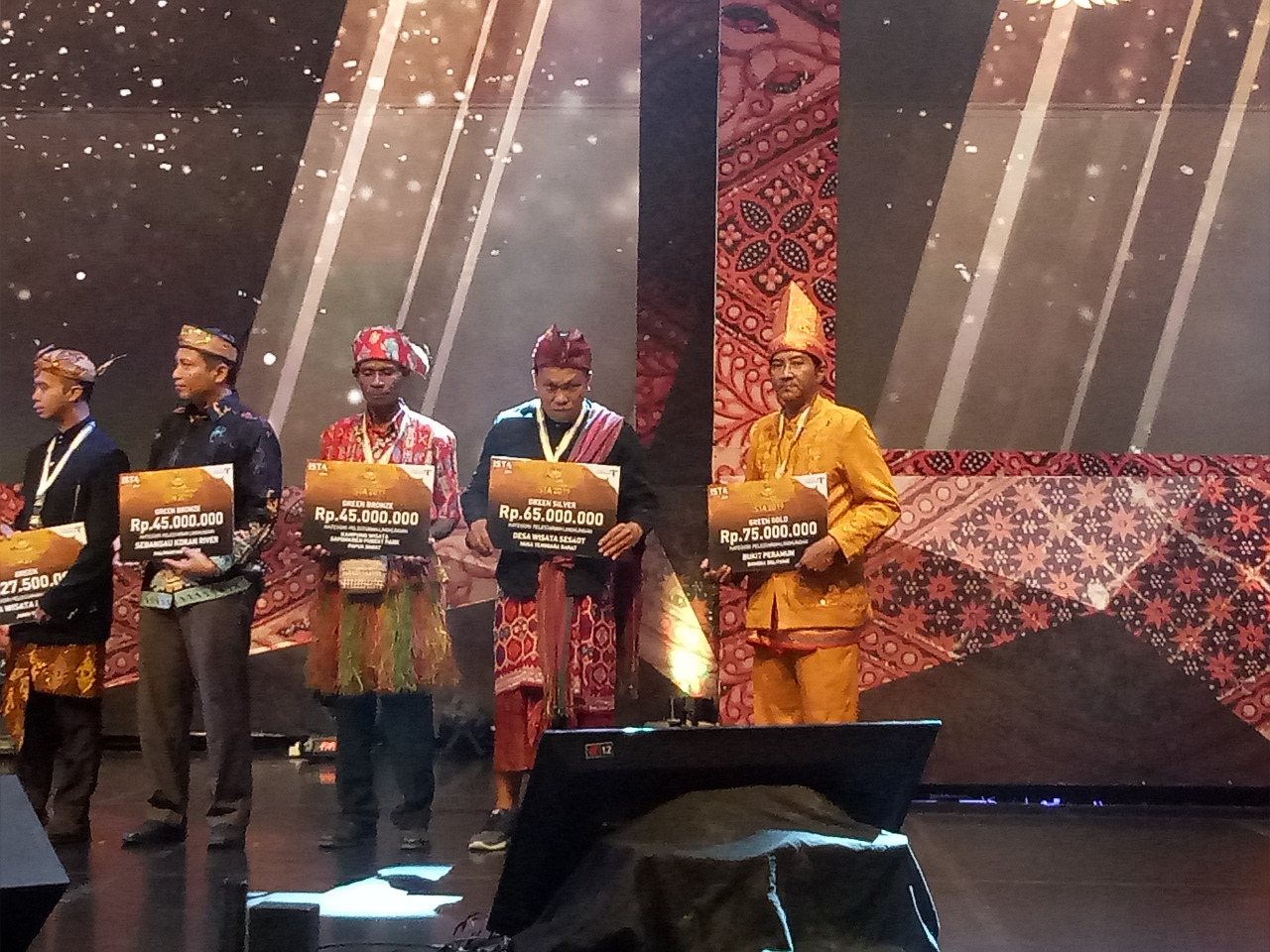 Adie Darmawan, Ketua Komunitas Arsel yang menjadi penanggung jawab Desa Binaan Bukit Peramun, saat menerima penghargaan.