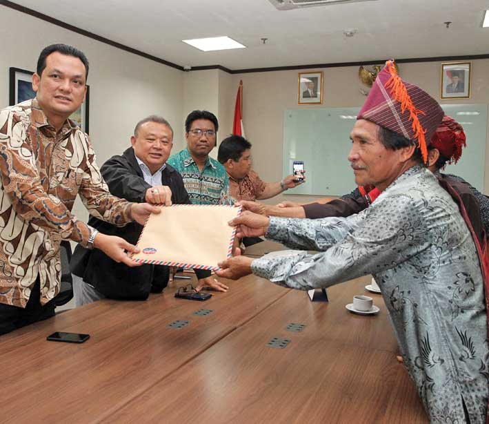 Anggota DPR dari Fraksi NasDem Martin Manurung (kiri) menerima berkas pengaduan masyarakat adat Desa Sihaporas, Kecamatan Pematang Sidamanik