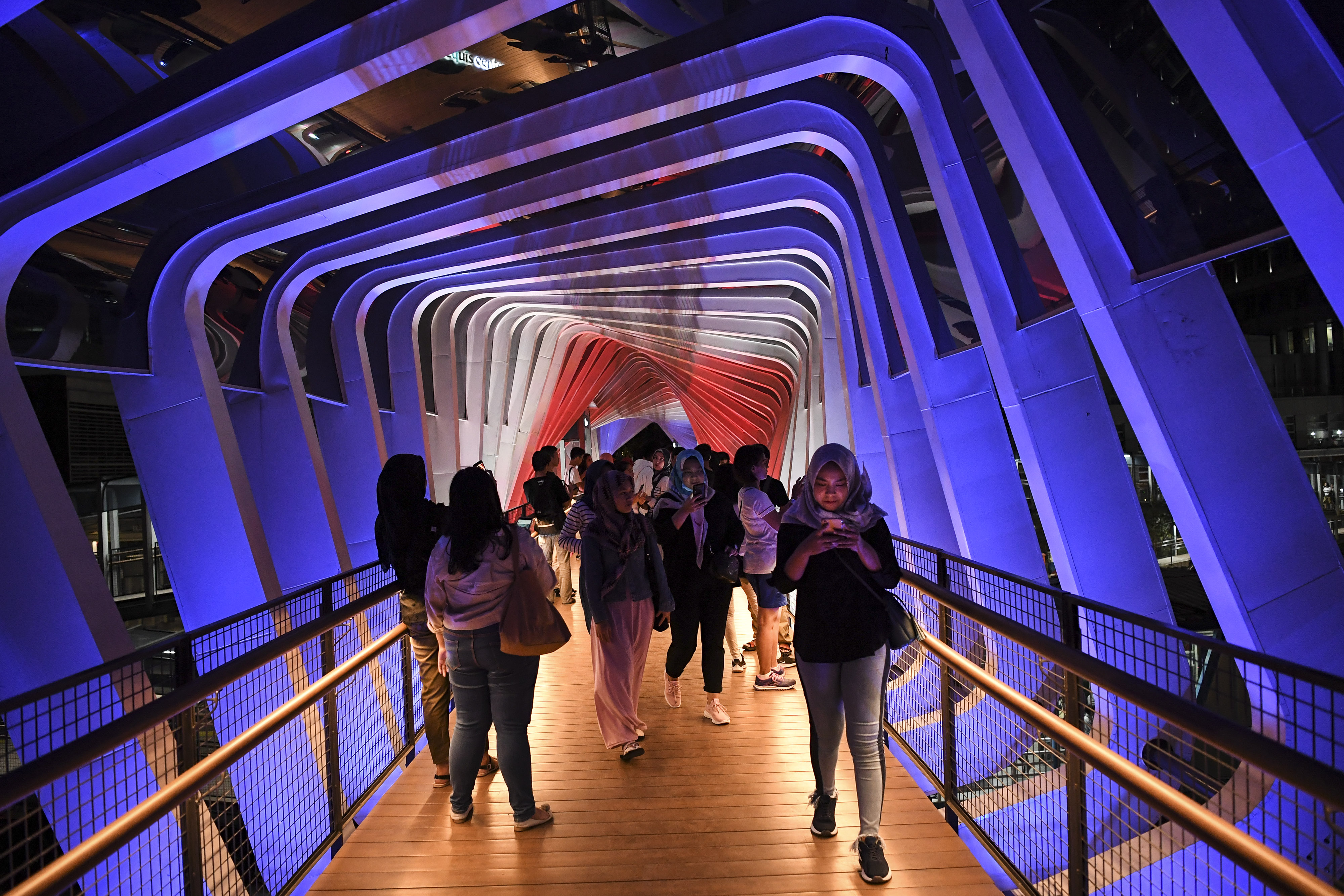 Warga berjalan di Jembatan Penyeberangan Orang (JPO) Gelora Bung Karno (GBK) 