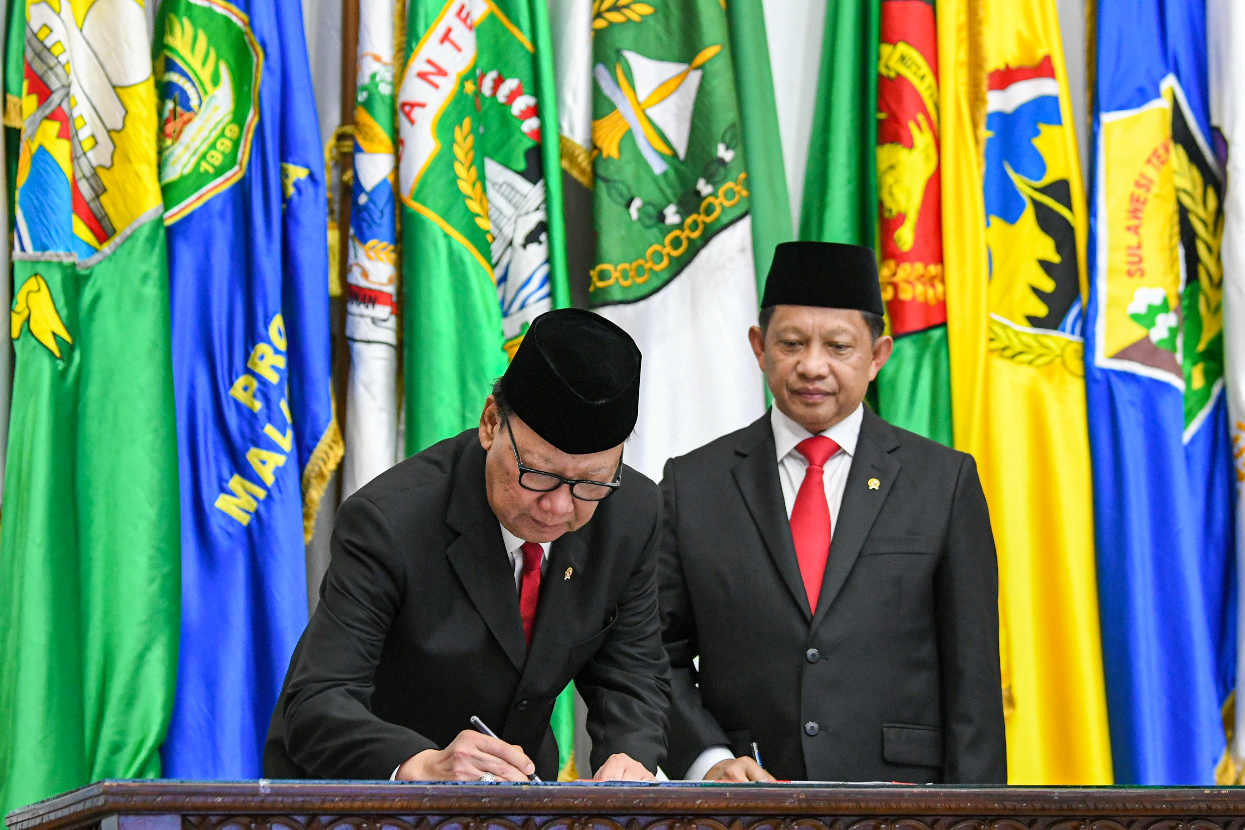 Mendagri Tito Karnavian (kanan) menyaksikan pendahulunya Tjahjo Kumolo menandatangani surat serah terima jabatan.