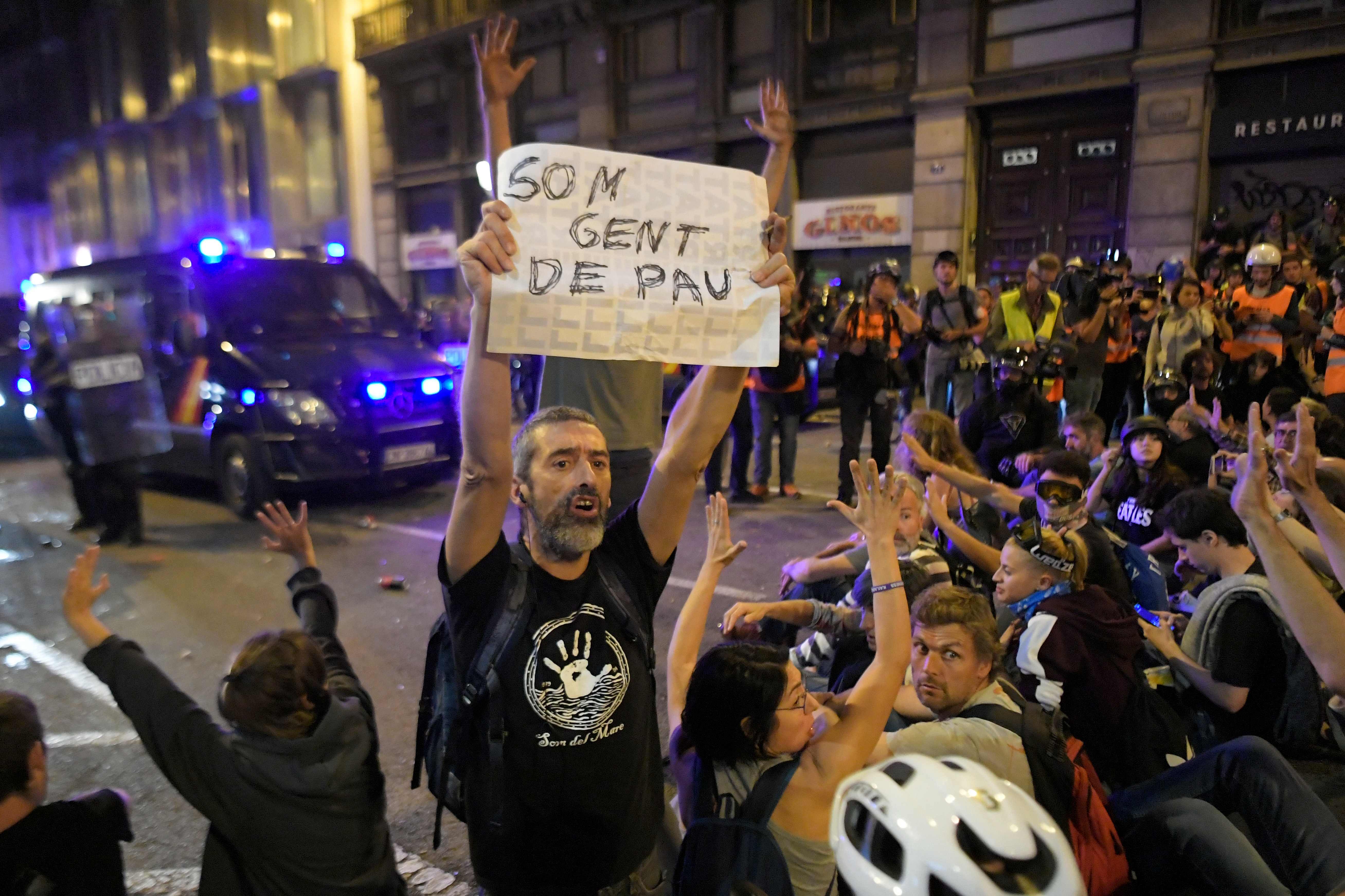 Seorang demonstran prokemerdekaan mengangkat poster bertuliskan 'Kami Orang yang Damai' saat berunjuk rasa di Barcelona, Catalonia.