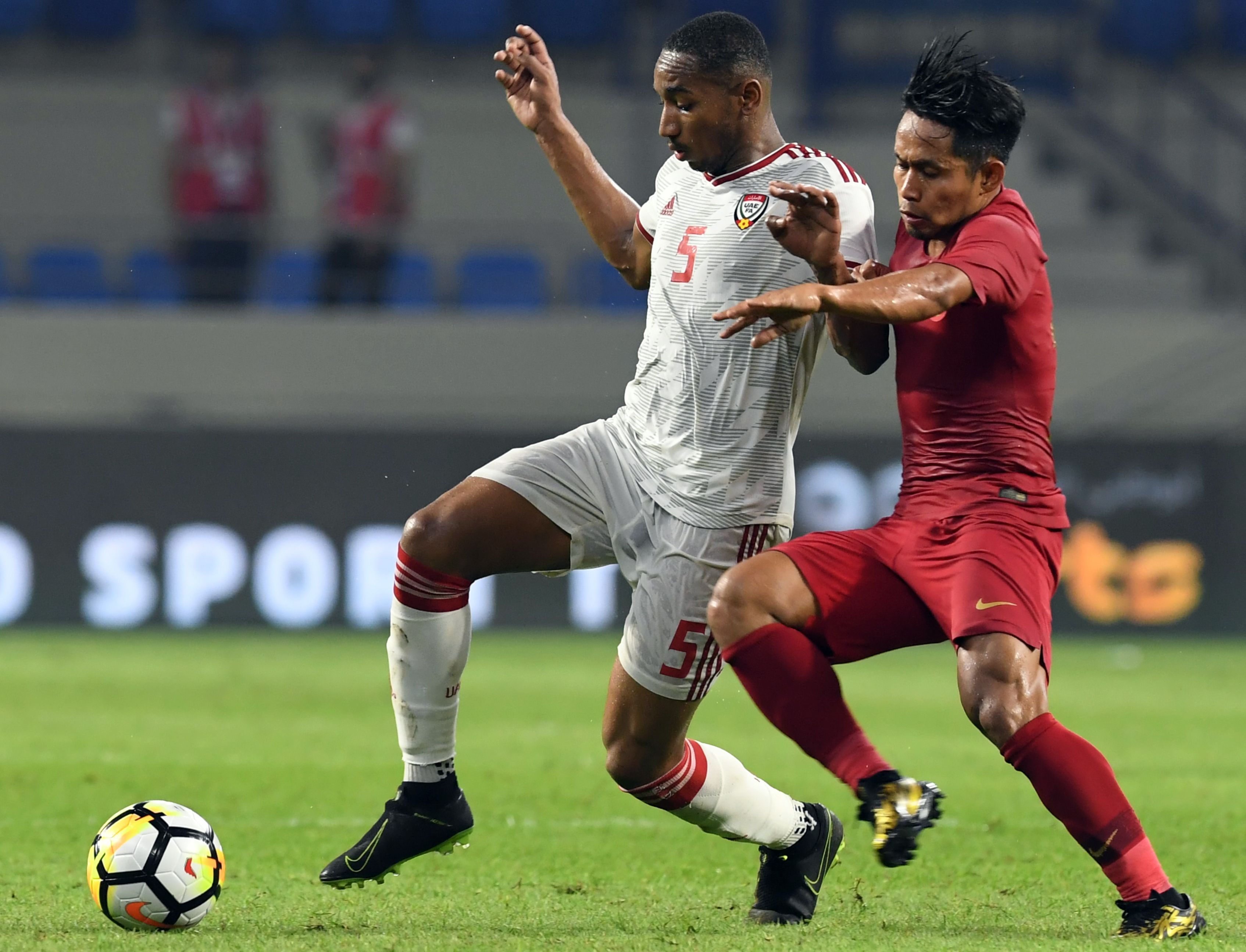 Gelandang tim Uni Emirat Arab (UEA) Ali Salmeen (kiri) ditempel gelandang timnas Indonesia Andik Vermansah.